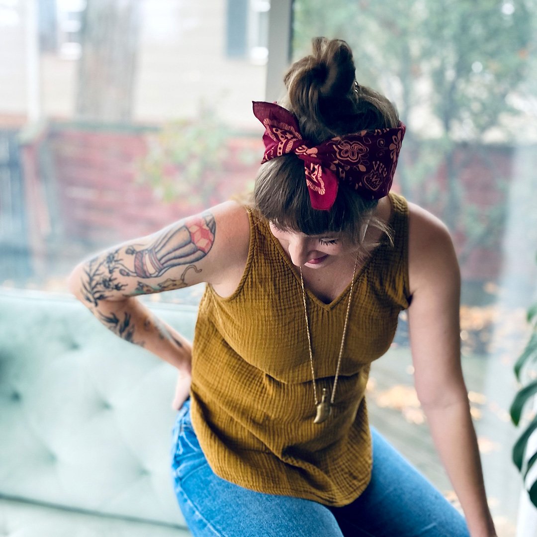 young woman wears sugar camp feminist cotton bandana styled into top knot updo.