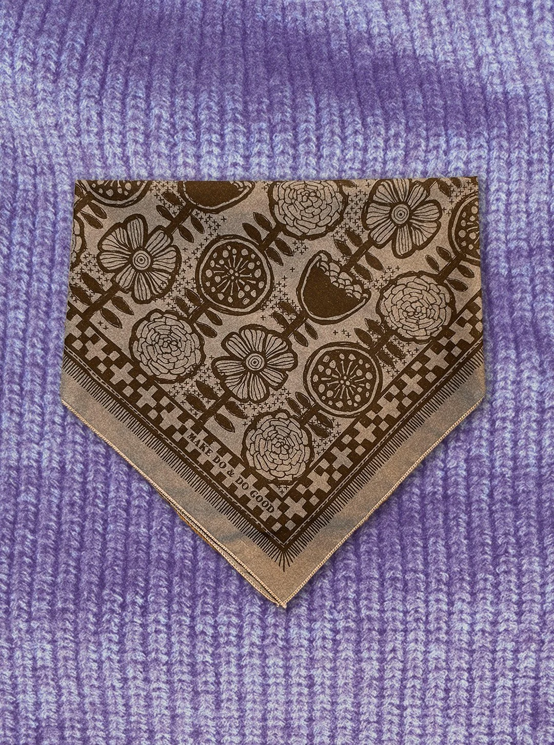 Sugar Camp sand-colored bandanna with brown ink features hand-drawn Scandinavian florals florals and stitches collaged on a knit background