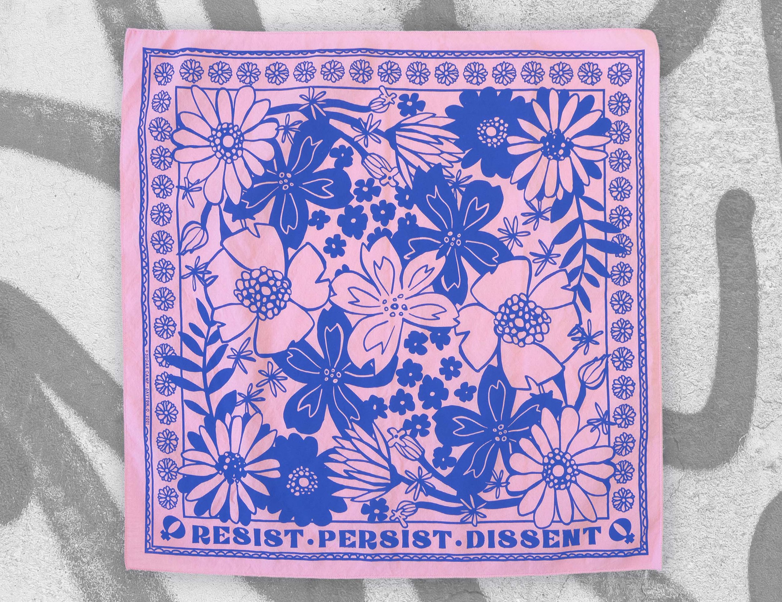 Trans pink & blue 'RESIST' bandana inspired by feminist icons, flat over graffiti background, makes a great gift.