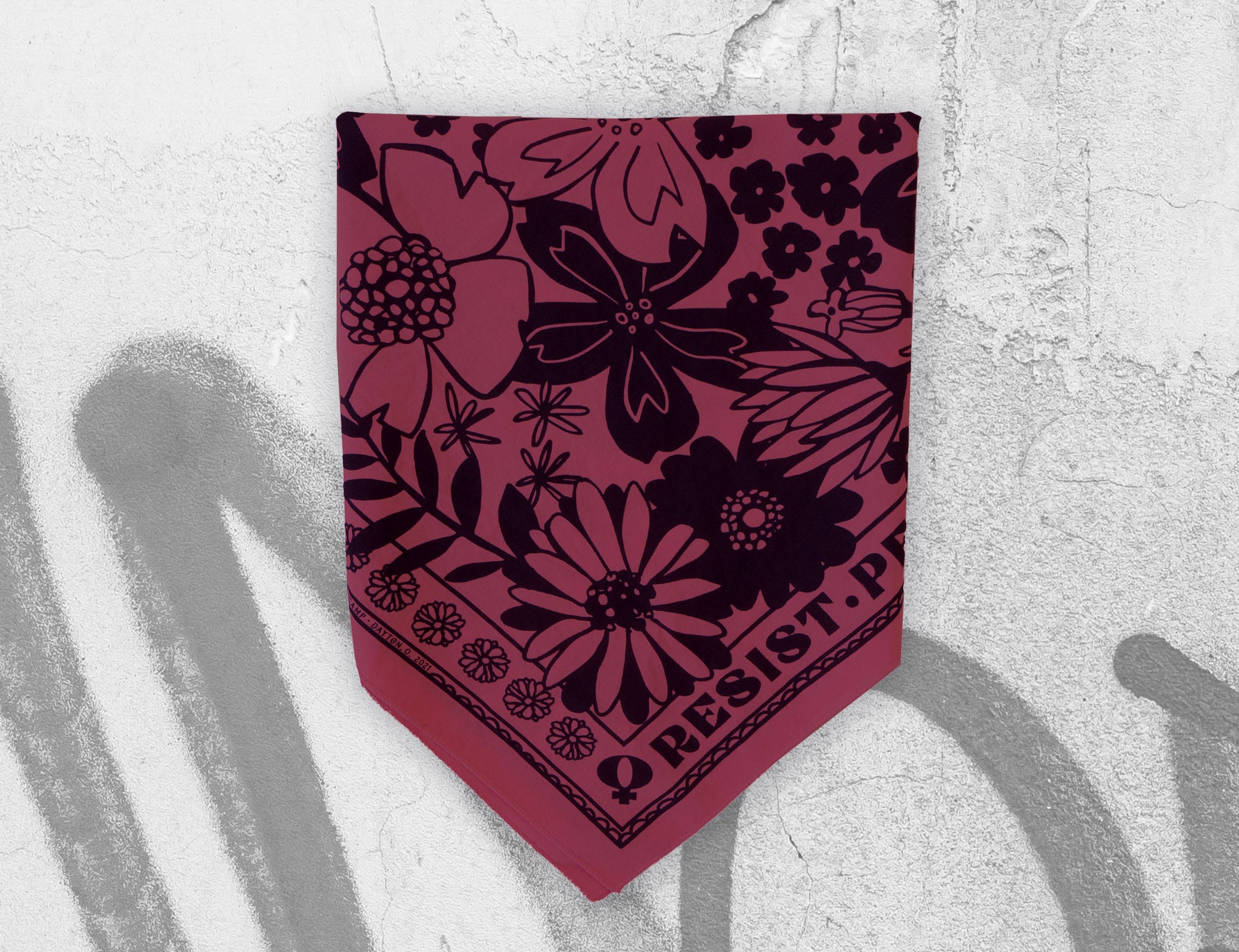 Folded burgundy floral bandana with bold 'RESIST' text, inspired by Elizabeth Warren, Ruth Bader Ginsburg, and Rosa Parks — feminist empowerment accessory promoting social justice and equality.