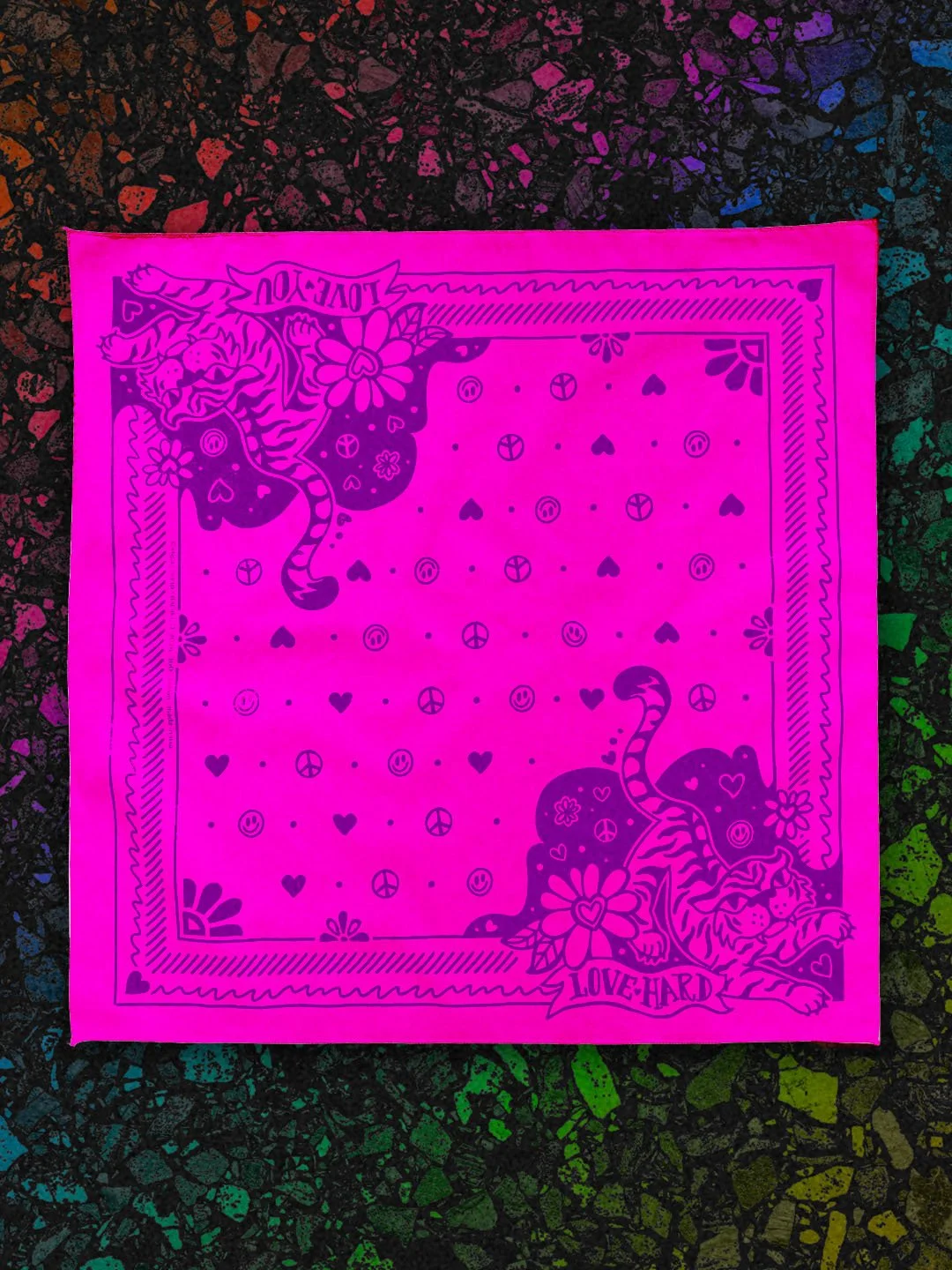 Love Hard Bandana by Sugar Camp in Hot Pink w/ purple ink, laid flat on a black rainbow terrazzo background. Features sweet, fierce tiger, hearts, smileys, and peace signs.