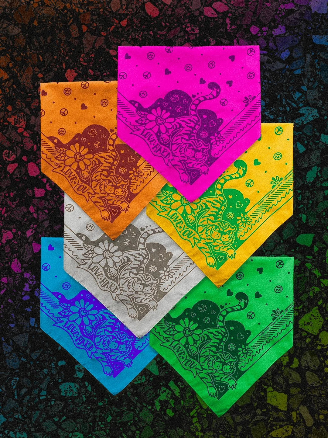 Love Hard Bandana rainbow collection by Sugar Camp in a spectrum of colors and ink, stacked on a black rainbow terrazzo background. Features sweet, fierce tiger, hearts, smileys, and peace signs.