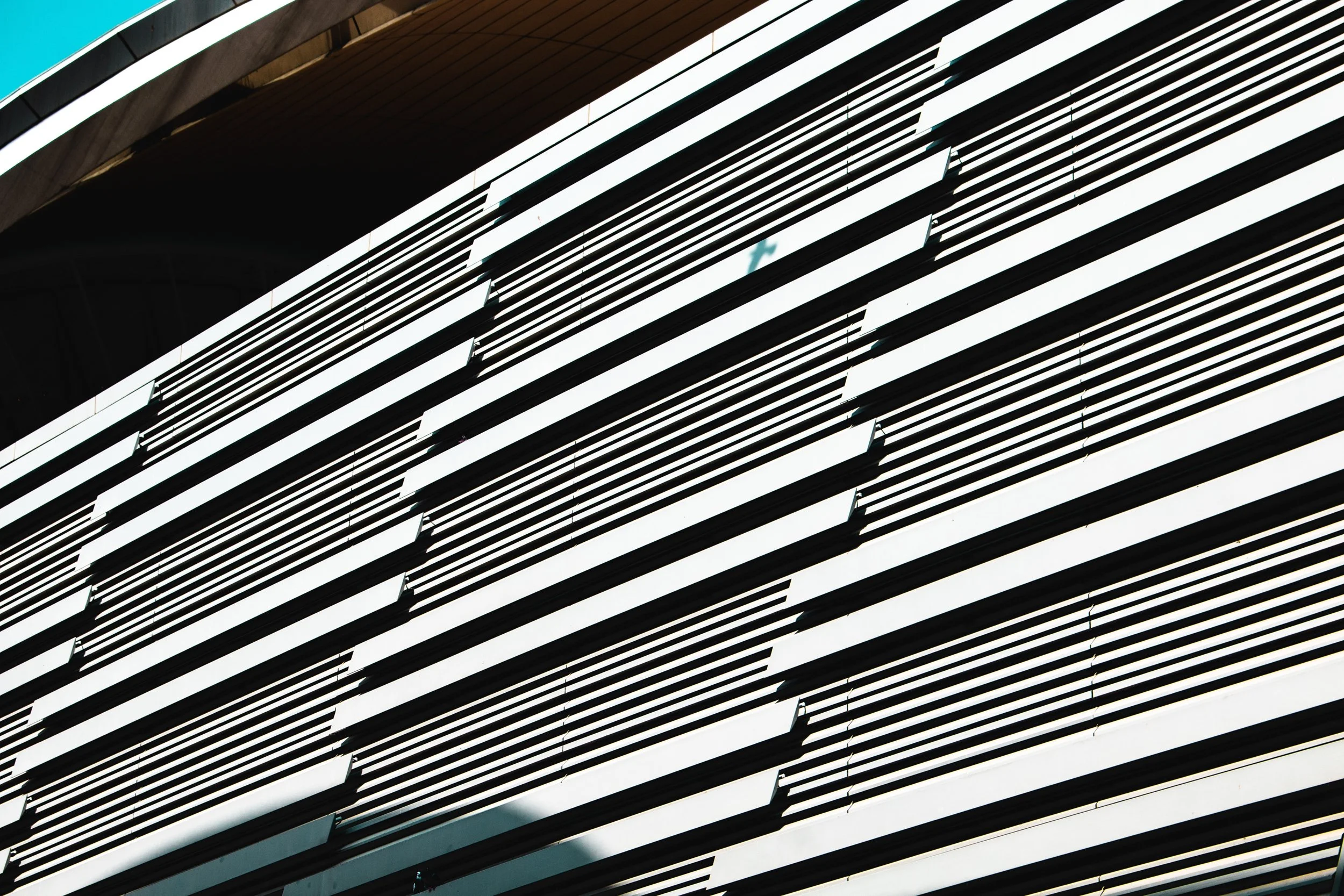 Modern building facade with horizontal white and black slats.