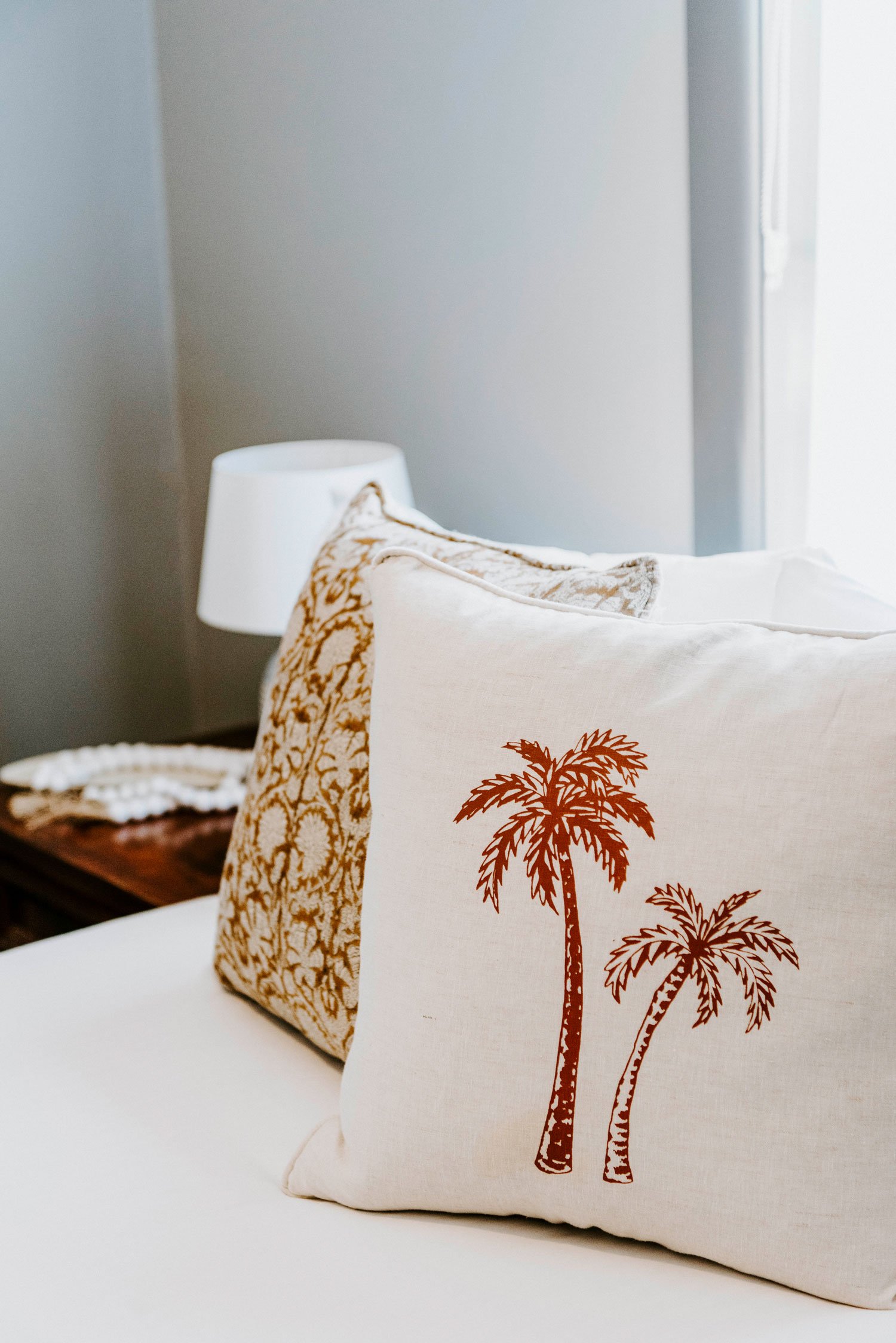 close up of a pillow with deep orange palm trees on it