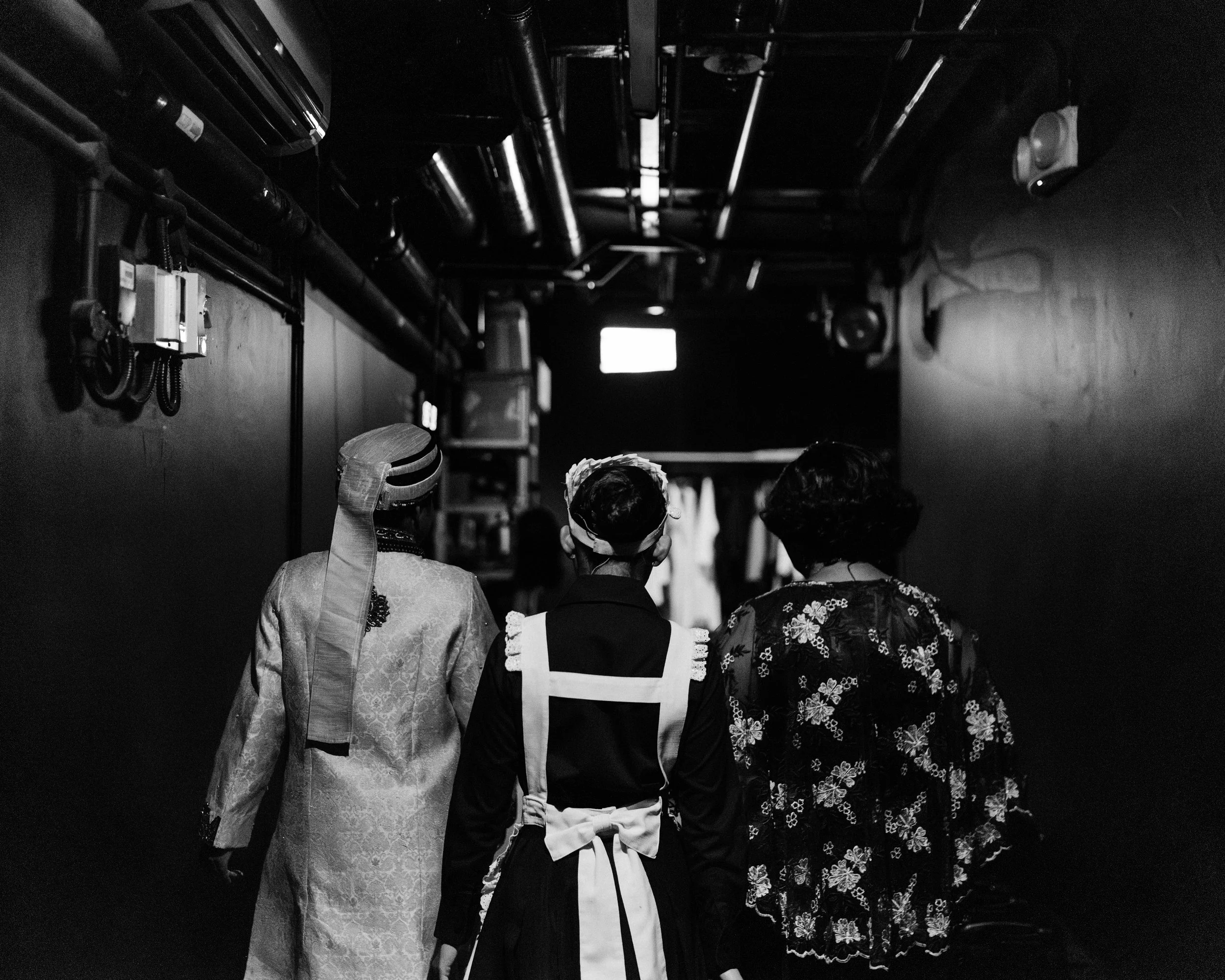 L to R: Sindhura Kalidas, Coco Wang Lin, and Siti Khalijah Zainal, backs facing us, all having just exited from Scene 1935 in costume.