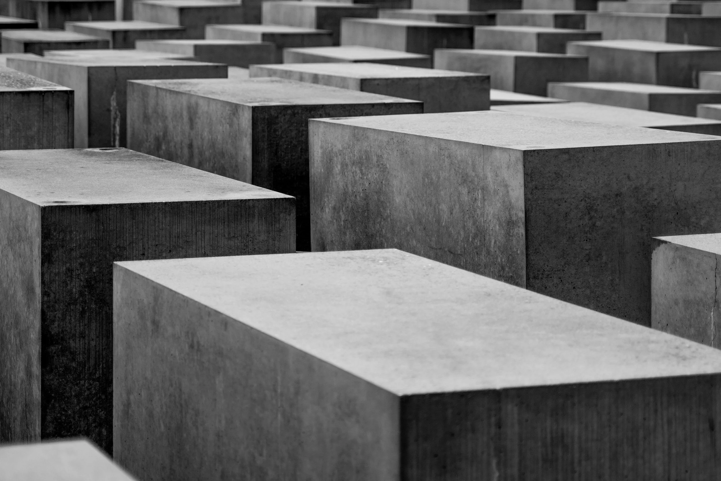 Black and white photograph of numerous concrete blocks arranged in a grid pattern, creating a geometric architectural design.
