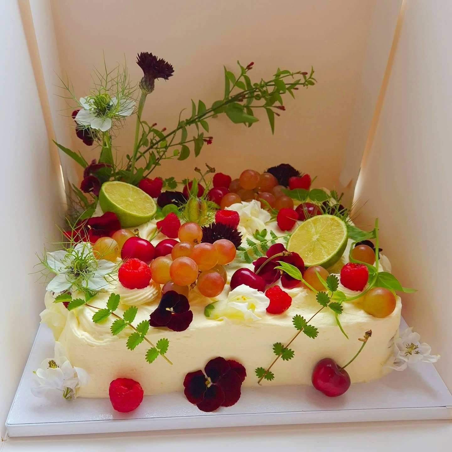 A cake worthy of a feast under the Roman frescoed ceilings was the inspiration for this bountiful, soft and romantic cake.

An understated luxury with the most beautiful,  edible &amp; organic blooms from @mel_luckhurst, muscat grapes, and ripe berri