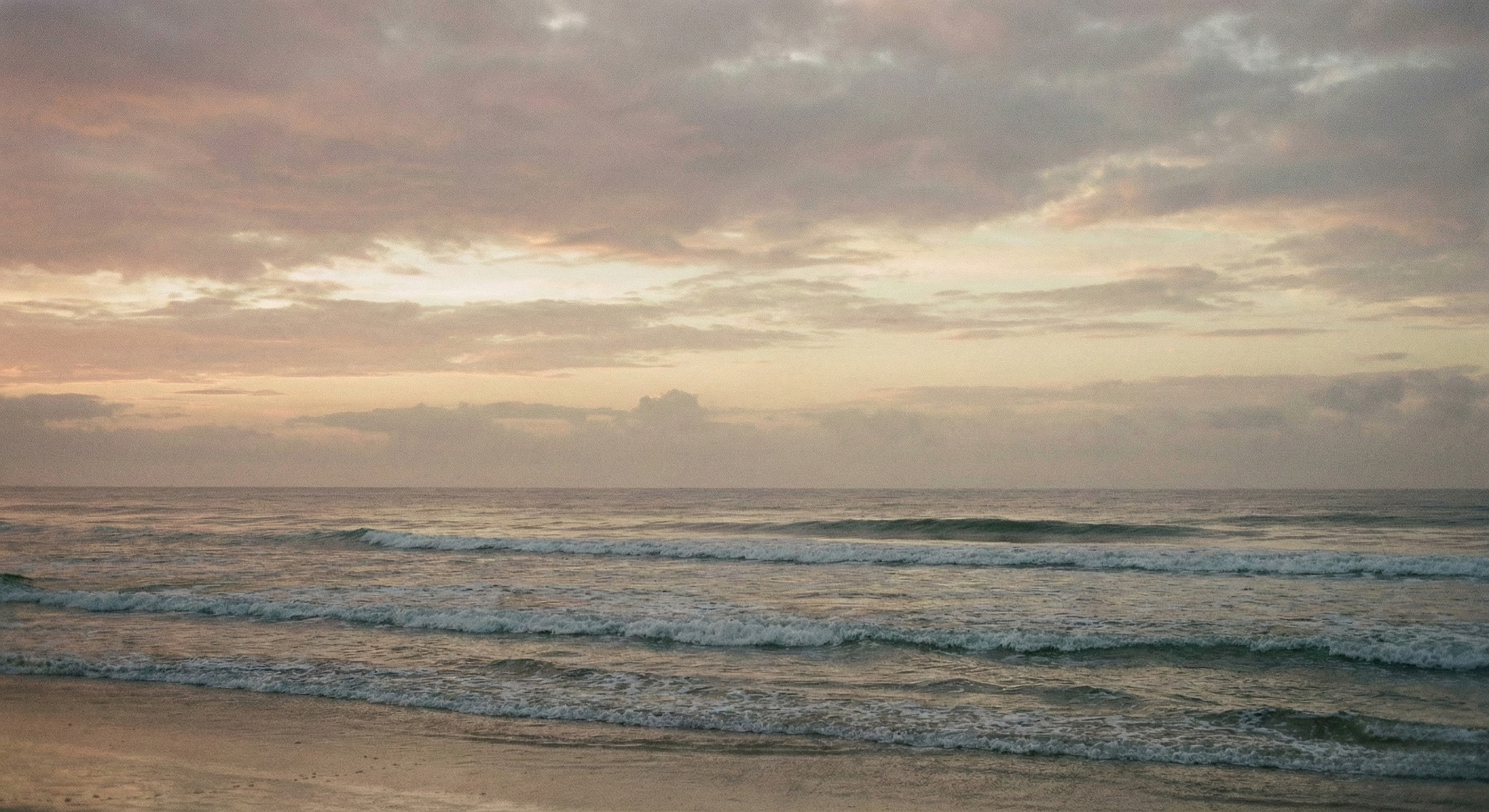 Gentle ocean waves under a soft sunrise sky, representing the peace, healing, and new beginnings found through virtual mental health counseling with Daybreak Therapy.