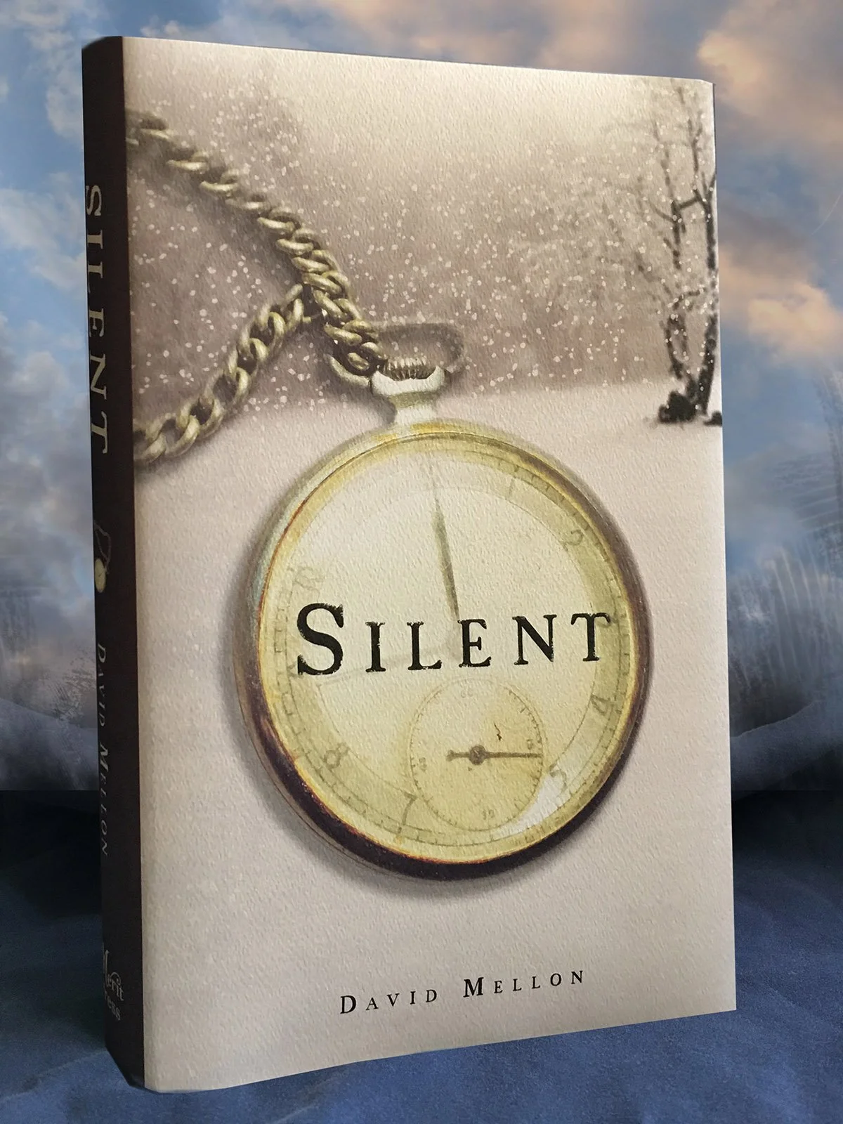 Book cover titled 'Silent' by David Mellon featuring a pocket watch and a chain in a snowy landscape.