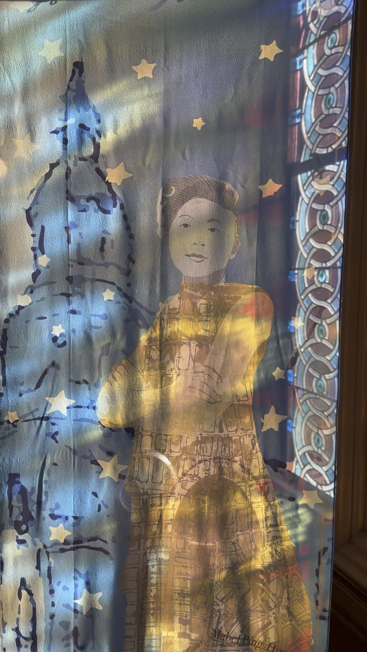 A creative glass window projection showing a woman in a yellow dress, a blue-capped building, star-shaped lights, and a detailed patterned background.