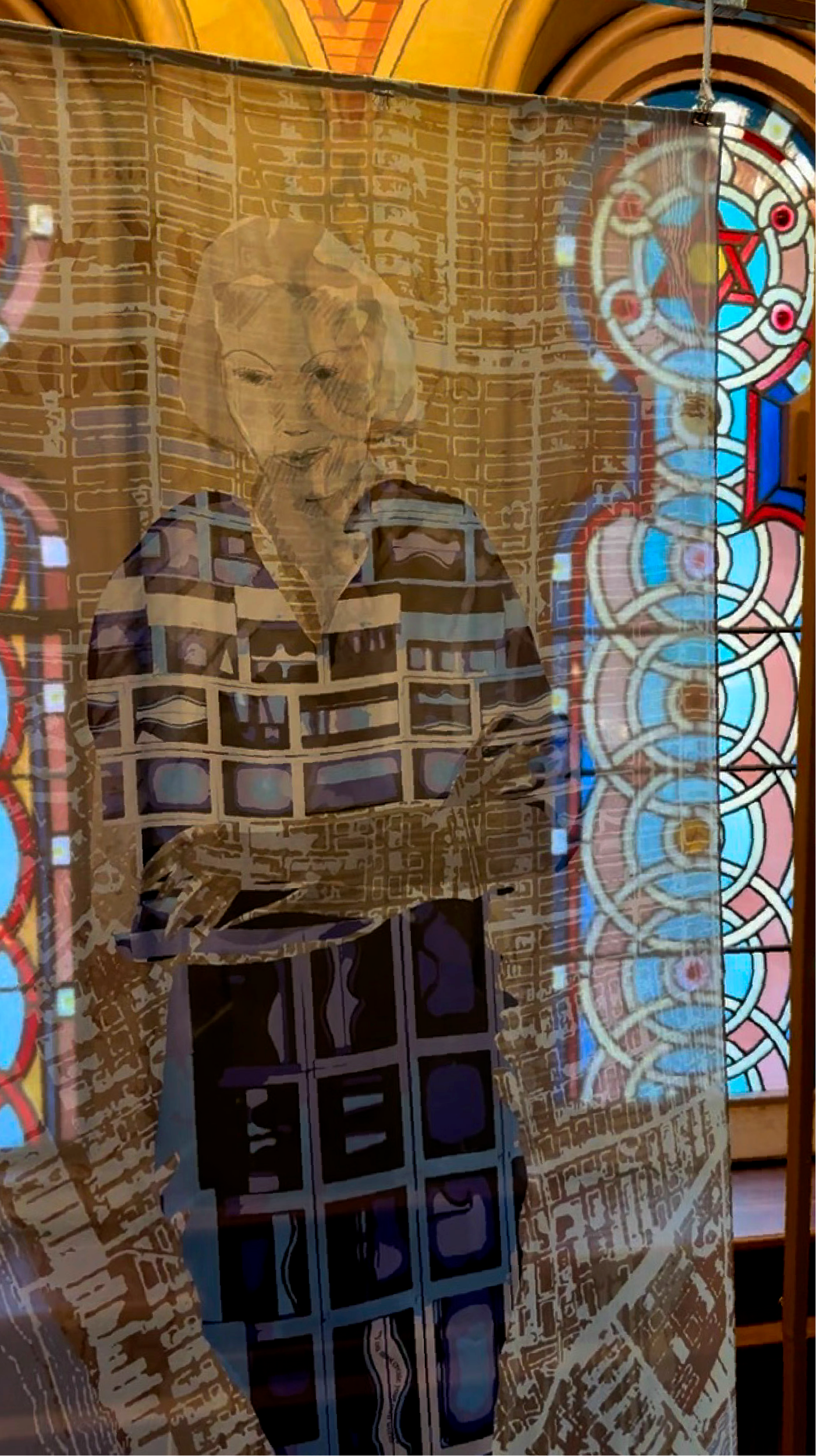 A layered stained glass window with a superimposed portrait of an elderly woman with short hair, smiling, inside a church or similar building.