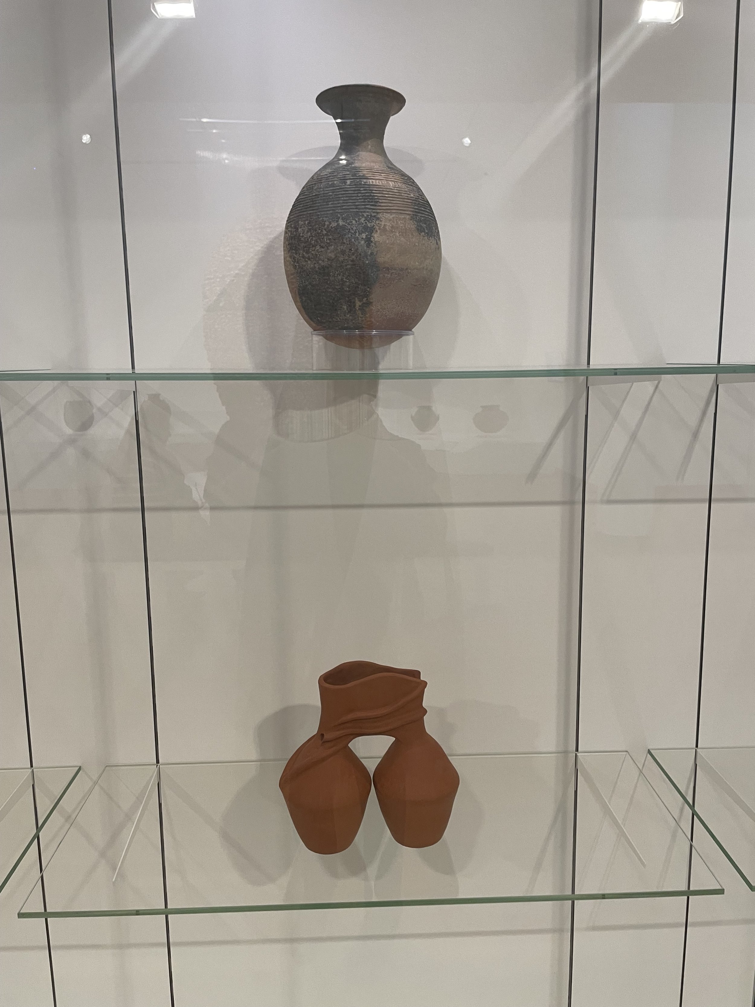 (Top) Artists once known, Mali. Beige and Black vessel. Before 17c. Terra-cotta. (Bottom) Bisila Noha, Reunion IX Following the light. 2023.Terra-cotta.