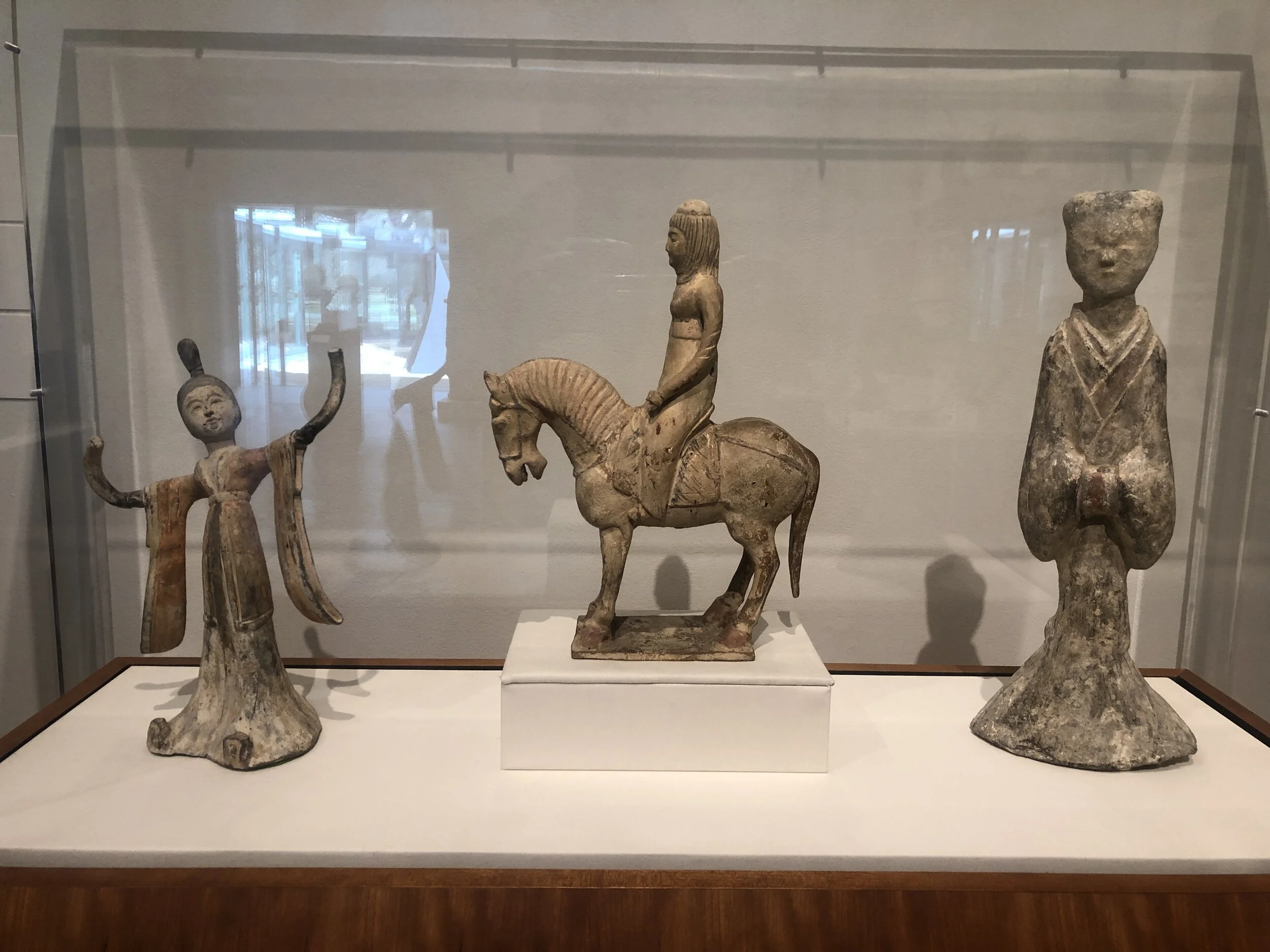 From left to right: Chinese - Tang Dynasty 618-907, Dancing Girl, 7th c., (earthenware with pigment), Chinese - Sui Dynasty 581-618, Equestrian, (straw-glazed earthenware), Chinese - Han Dynasty 206 BCE-220 CE, Standing Female Attendant (earthenware 
