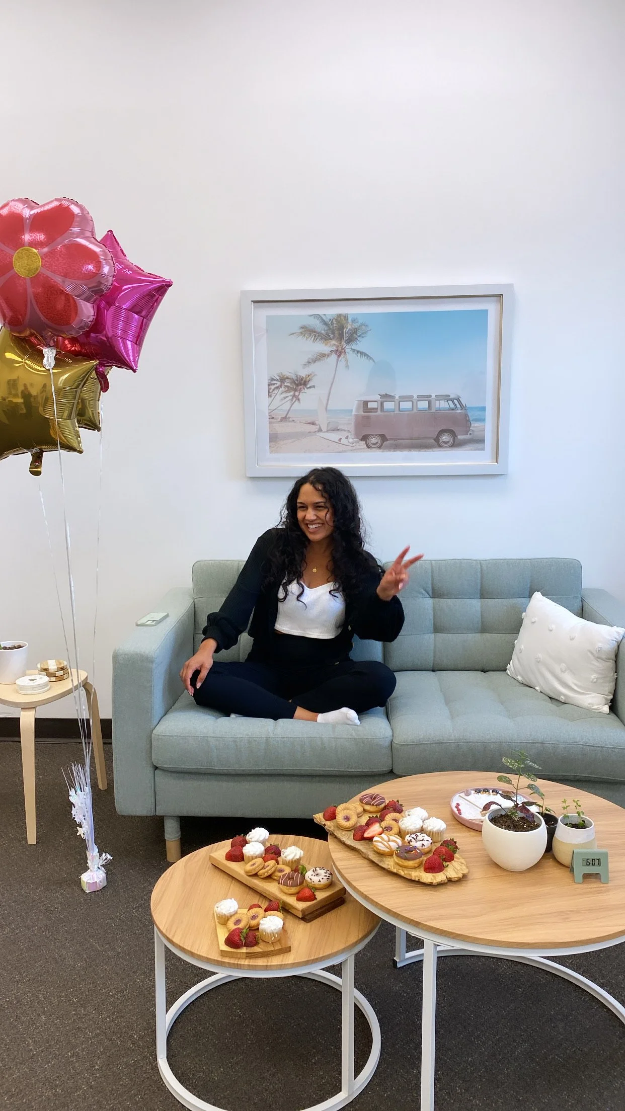 A workshop facilitator sitting comfortably on a couch in a bright, welcoming space, smiling warmly.