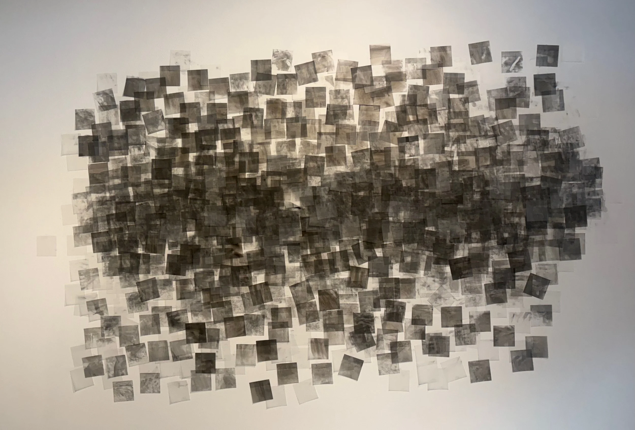 Dreams, hopes, and to-do lists, 2026, Charcoal and post-it notes installation on existing drywall