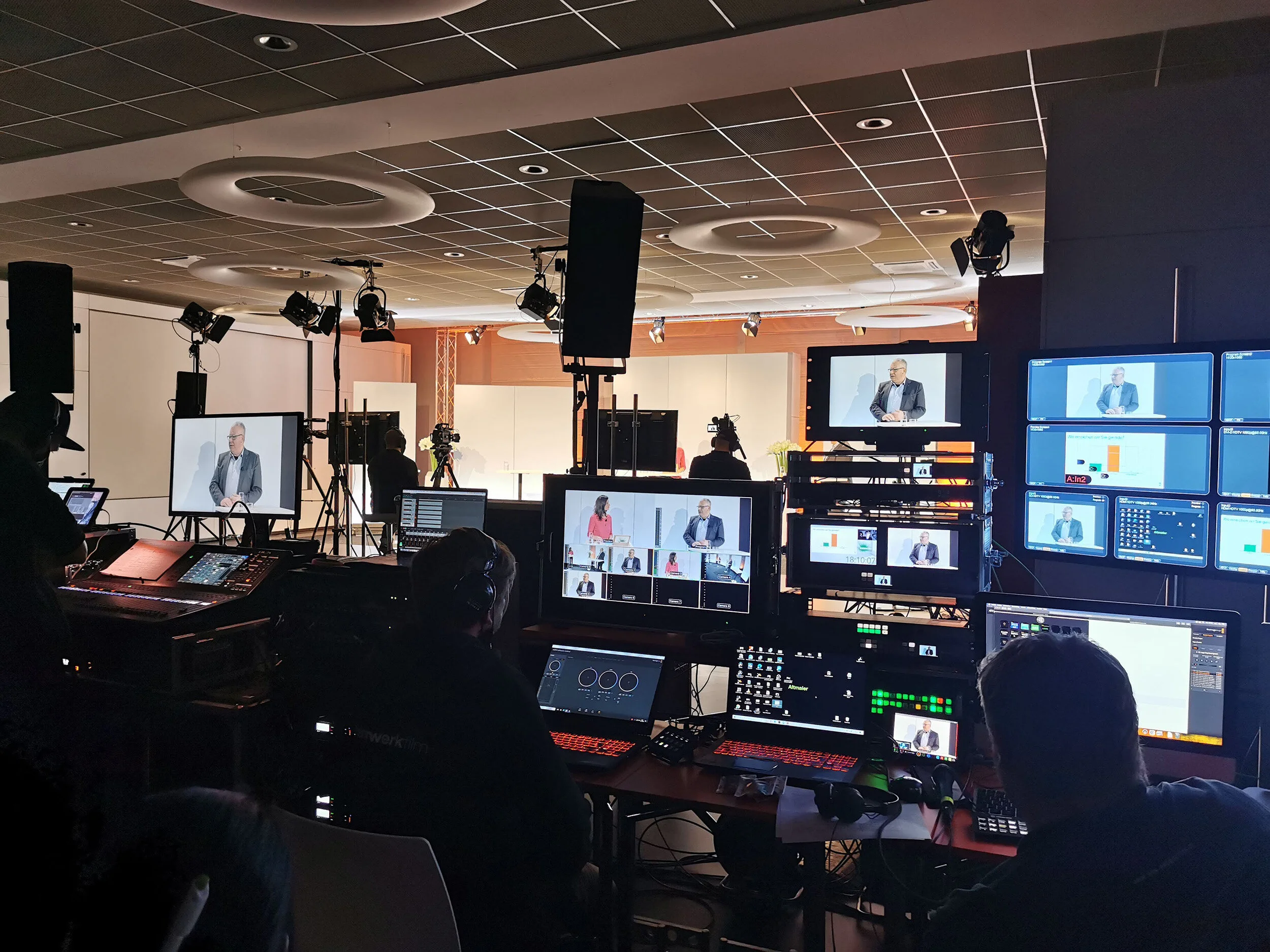 Blick in ein Studio aus Sicht der Techniker mit vielen Bildschirmen und Technik, die zu sehen ist