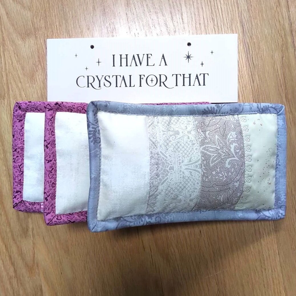 a 'I have a crystal for that' sign with three Healing Crystal Weighed Eye Masks in Pinks and Creams