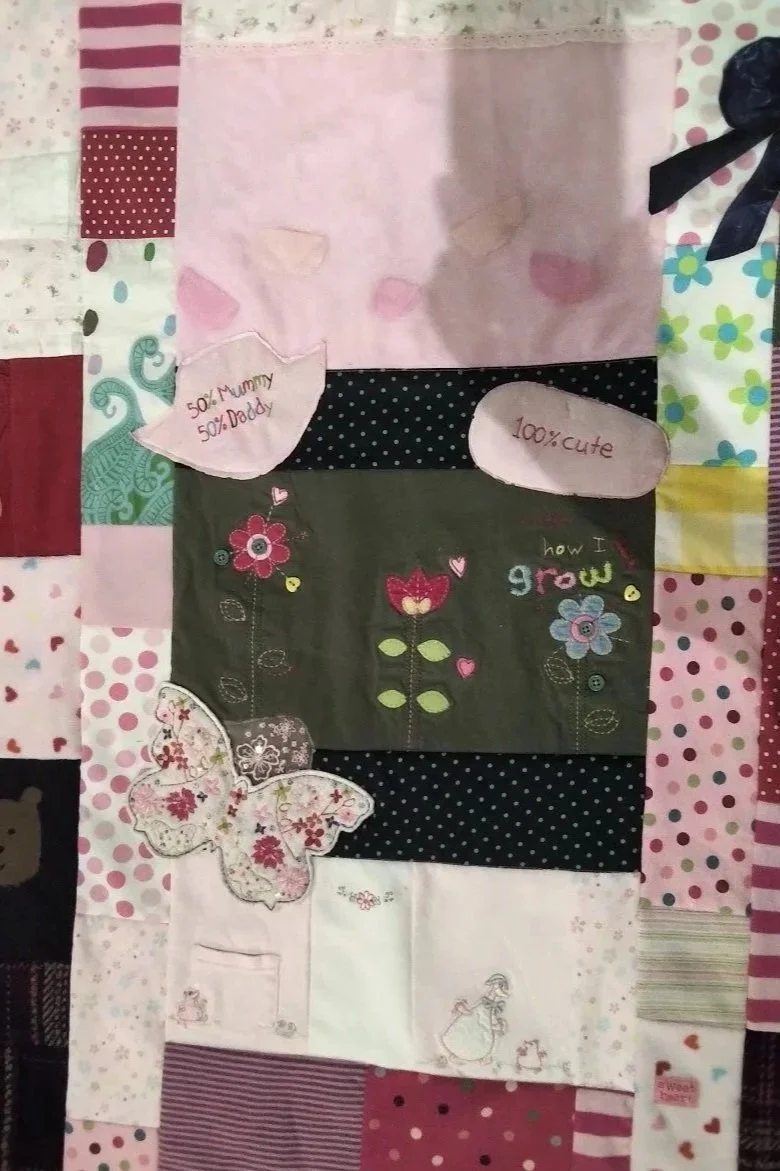 memory quilt using baby girl clothing mainly in pink and cream