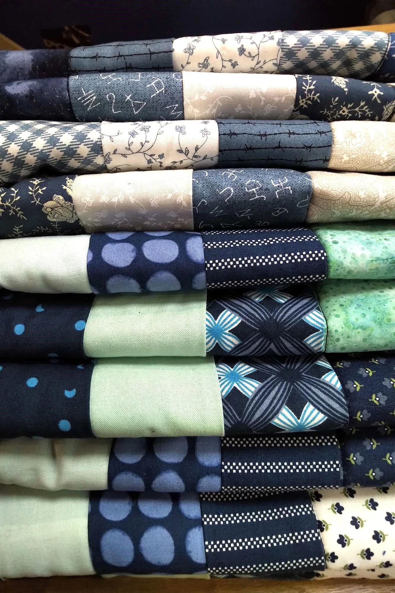 A king sized memory quilt made with shirts in blue, cream and turquoise