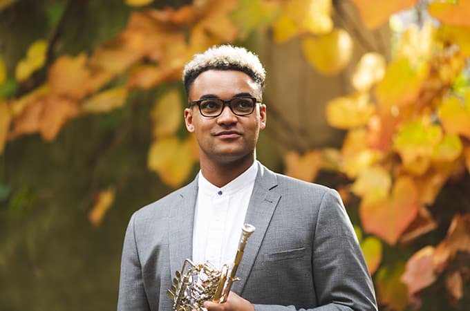 Aaron Akugbo outdoors with his trumpet