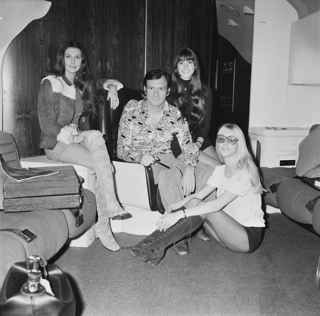 Hefner in his aircraft in London, before flying back to Chicago, 20th February 1971. With him are Playboy models (left to right) Marilyn Cole, Barbi Benton and Connie Kreski.