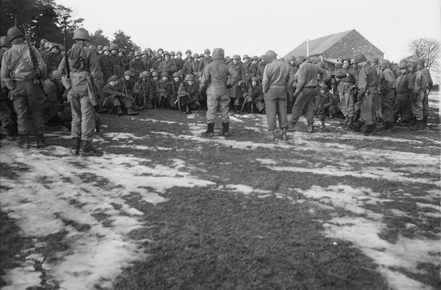 vaccaro_After the Battle of the Bulge, commanders of the 331st Regiment hold an impromptu meeting with thye troops to discuss options, near Bastogne, Belgium, January, 1945. .jpg