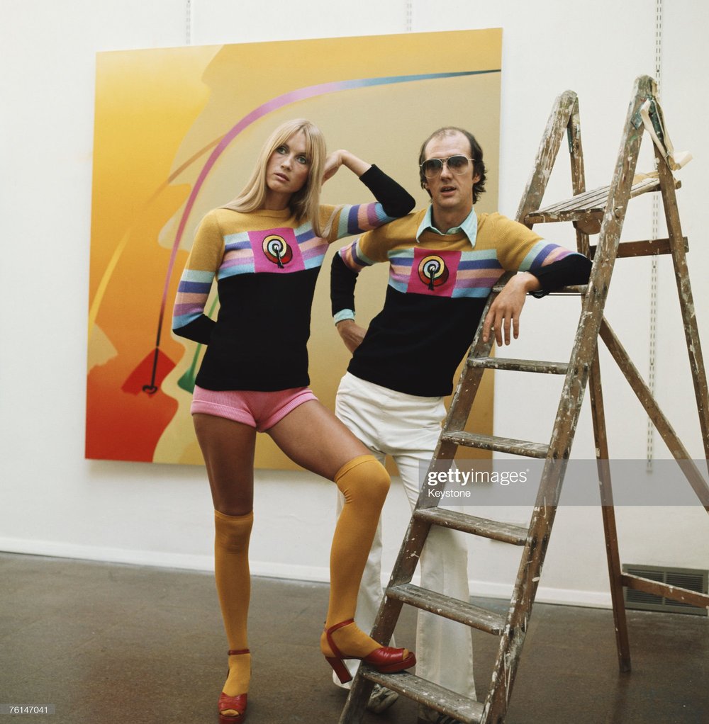 Allen Jones with a model in a gallery showing his work, circa 1970. The couple are wearing sweaters designed by Jones for the Ritva Man label. .jpg