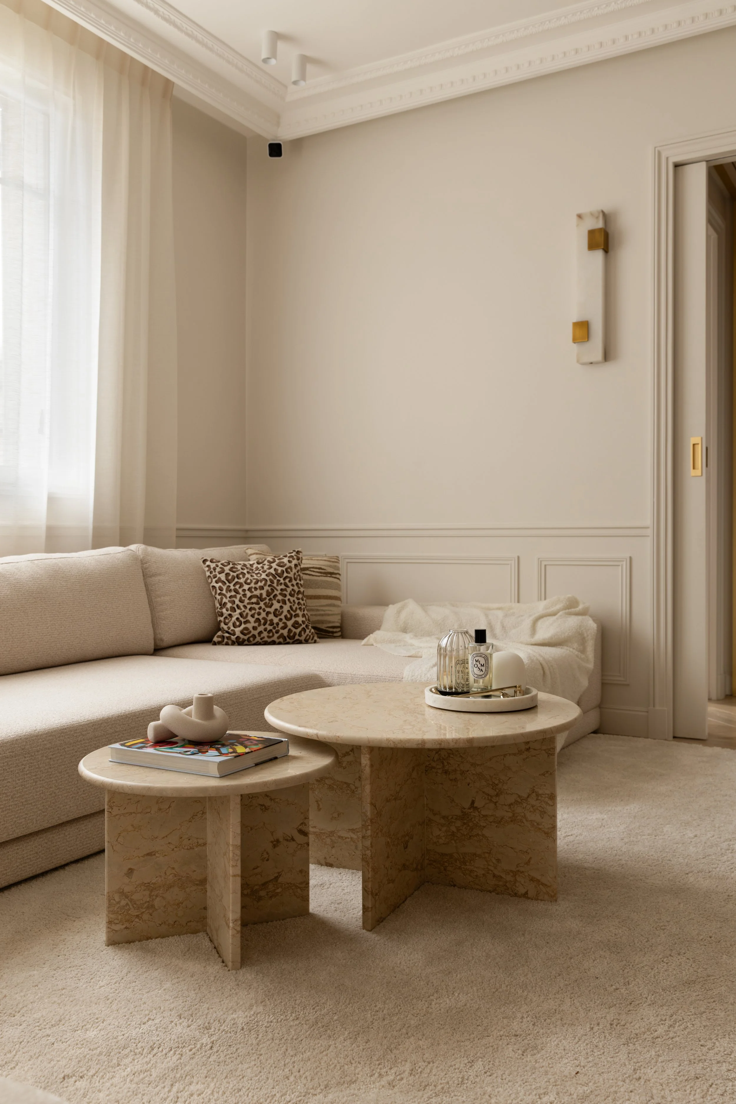 Salon minimaliste aux tons clairs avec mobilier arrondi et décoration élégante.