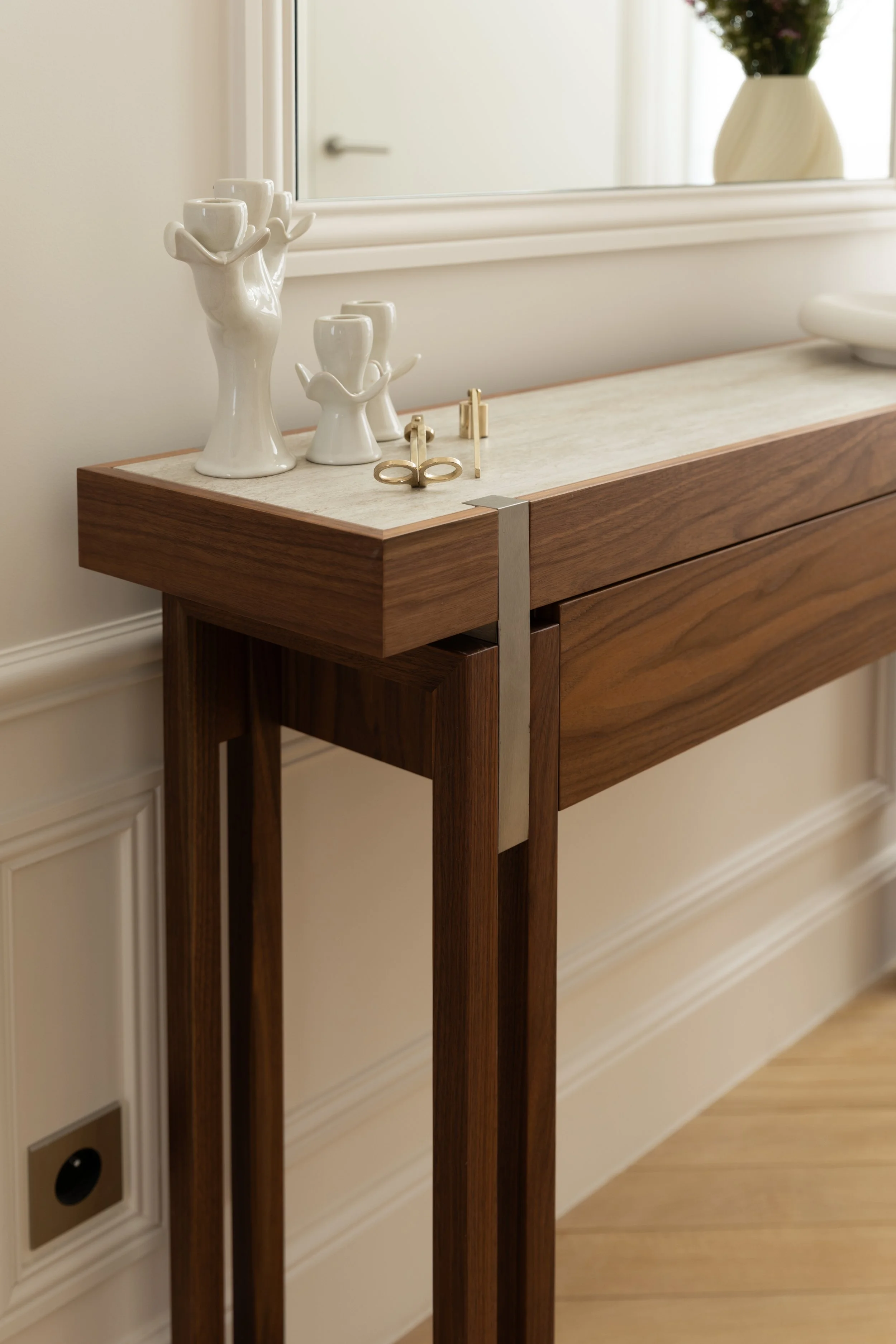 Console contemporaine en bois et pierre naturelle, objets décoratifs et finitions raffinées dans une entrée parisienne – Intérieurs Chomet.