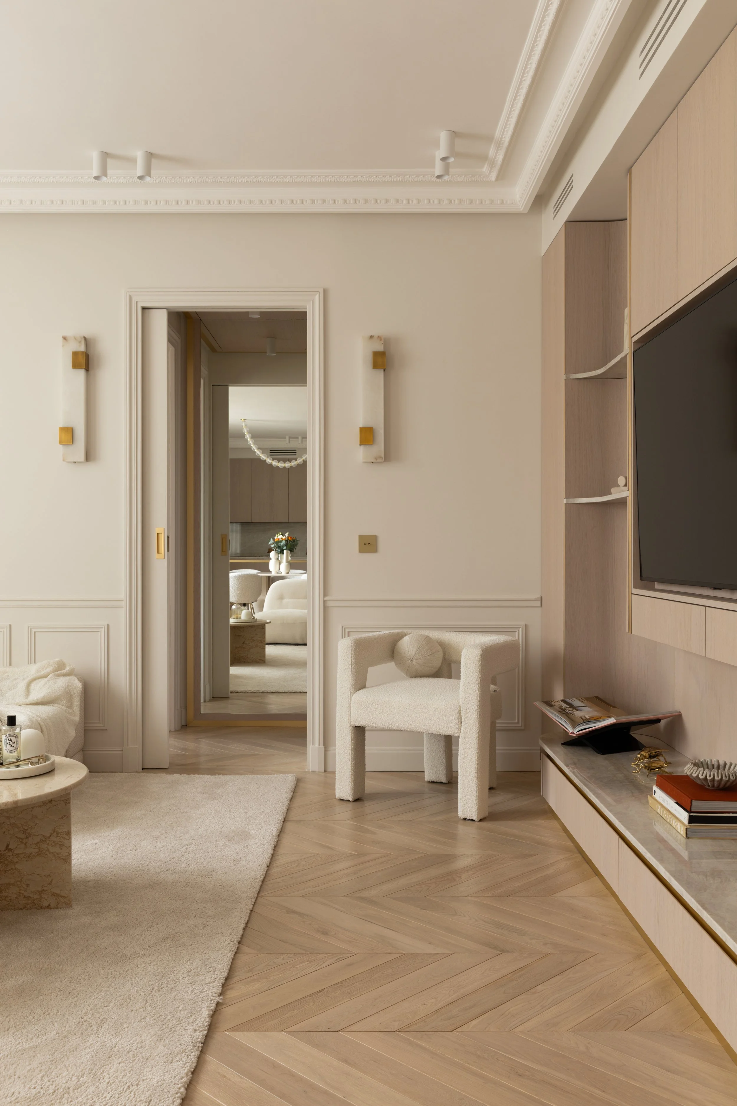 Perspective salon et couloir haussmannien
Vue sur salon lumineux et couloir haussmannien, décoration raffinée aux tons neutres et matériaux nobles.