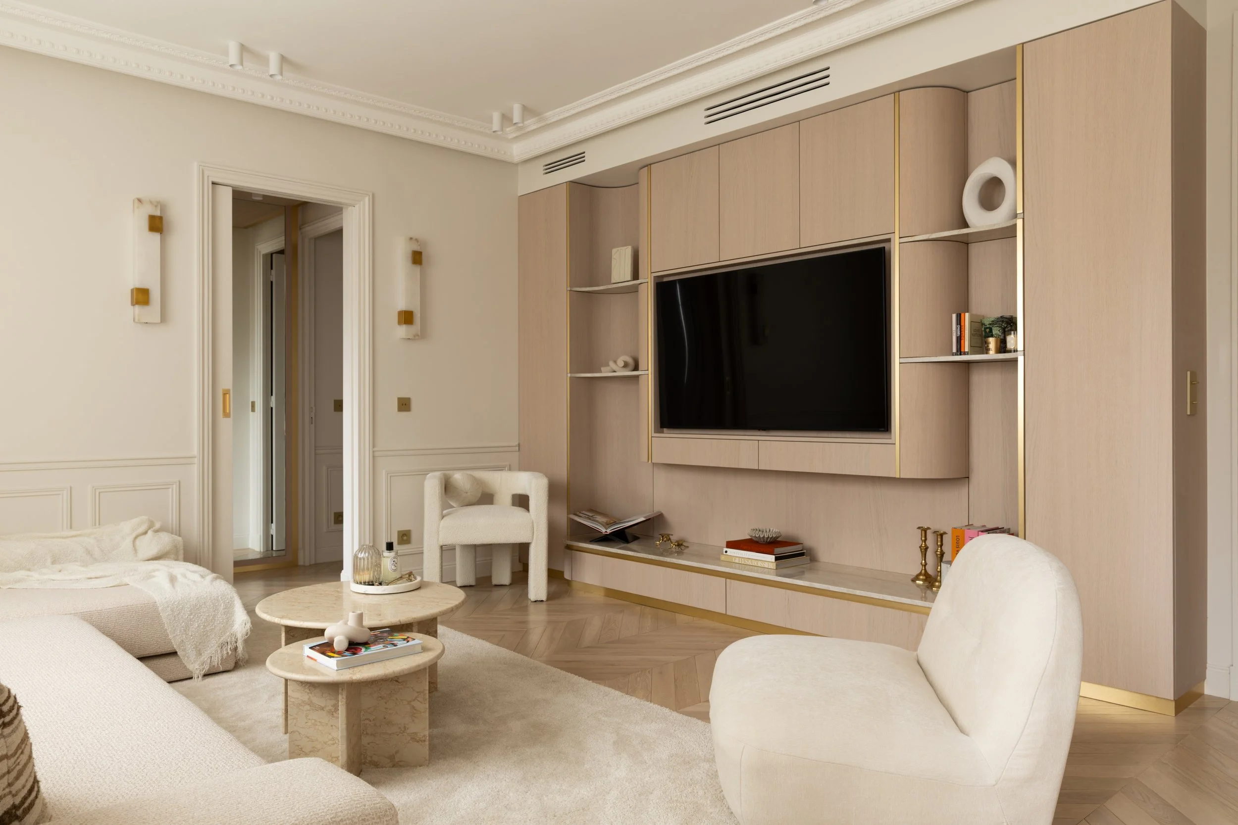 Salon design avec mobilier sur mesure
Salon contemporain avec meuble TV sur mesure, fauteuils texturés et palette de couleurs beige.