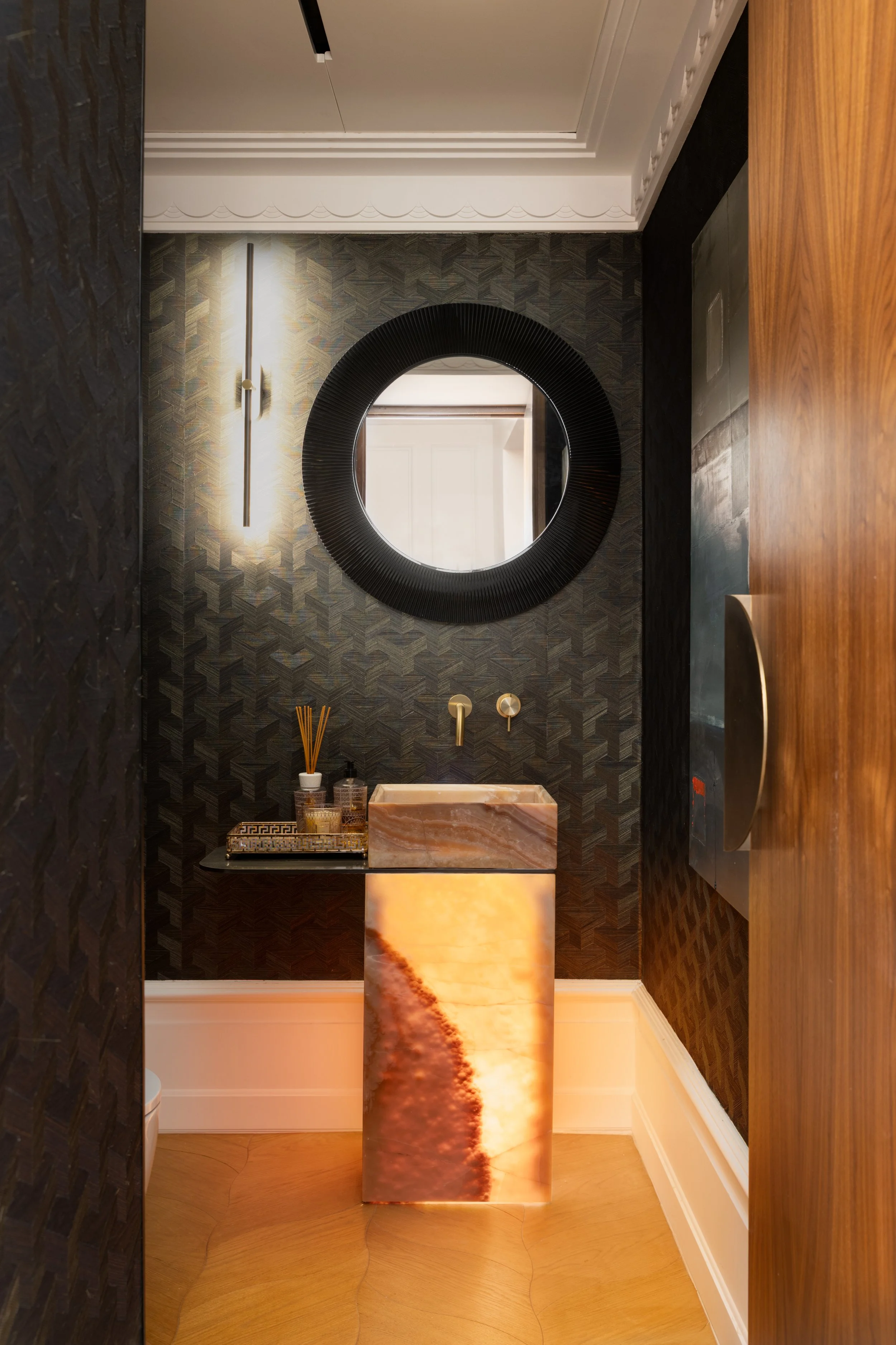 Toilettes invité avec vasque décorative en Onix rose rétroéclairée, design audacieux et élégant à Paris.