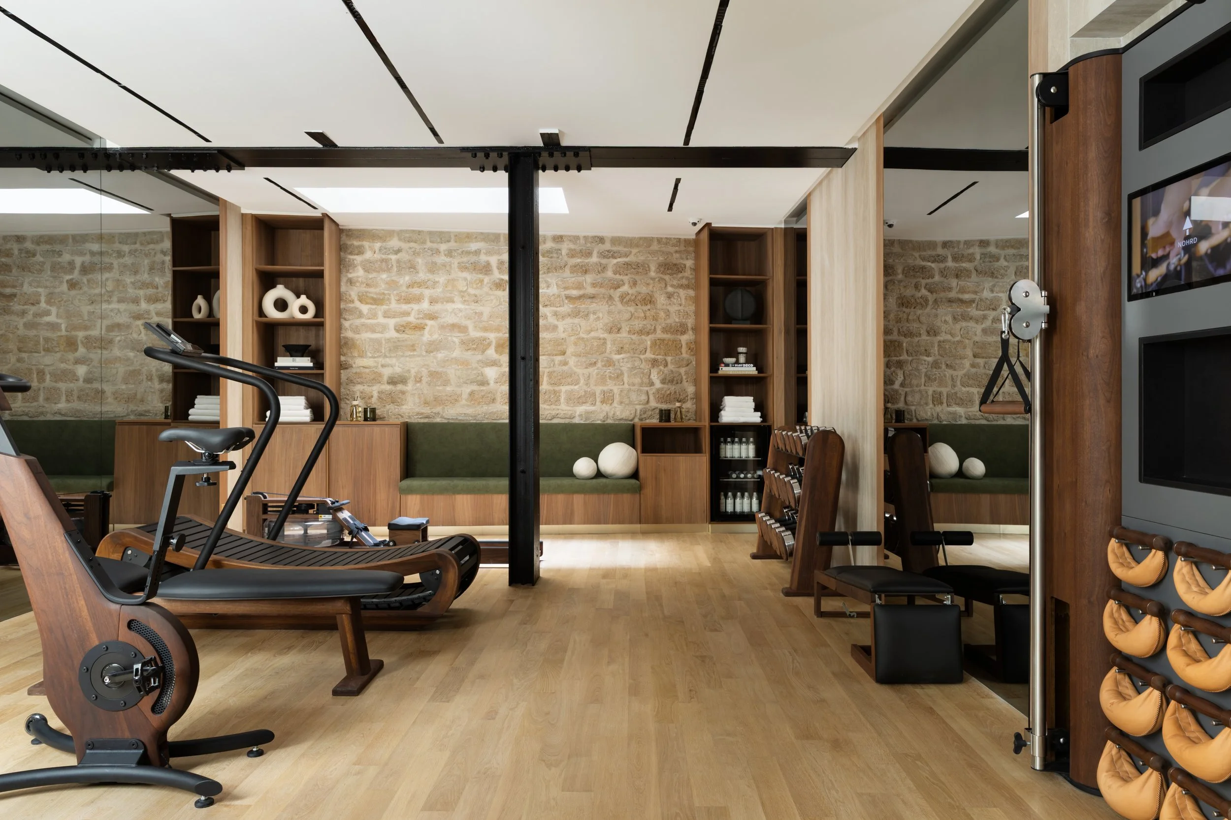 Salle de sport privée de luxe à Paris avec équipements de fitness, parquet en bois clair et aménagements sur mesure – Intérieurs Chomet.