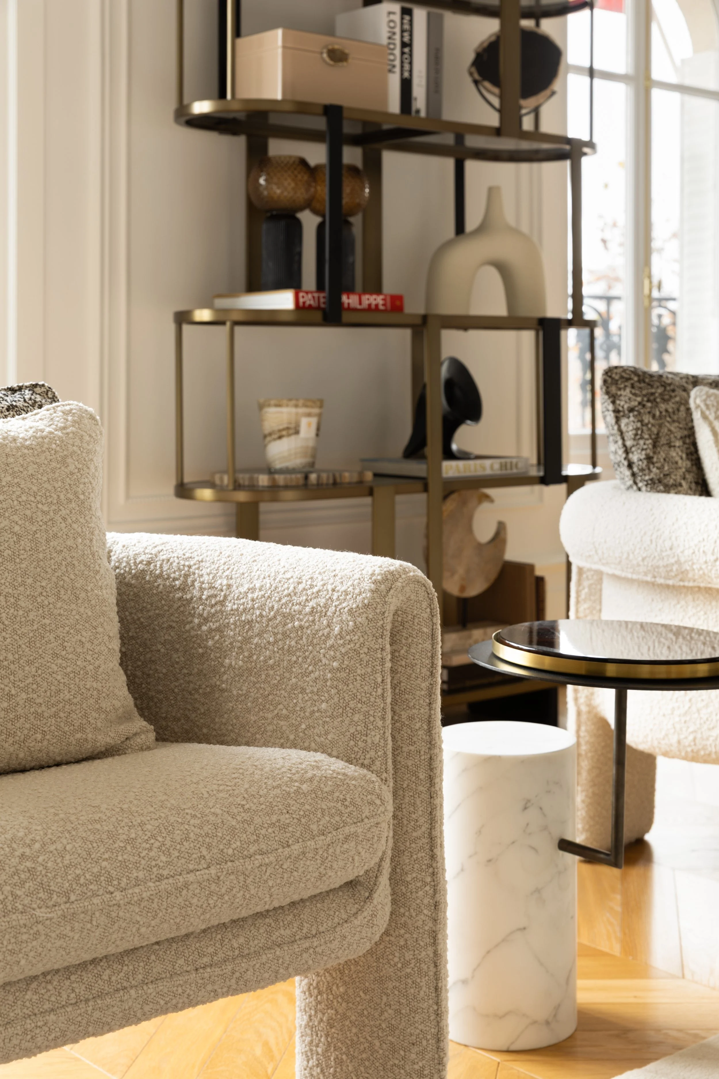 Détail de mobilier aux lignes courbes et étagère design, ambiance chaleureuse et contemporaine dans un appartement parisien.
