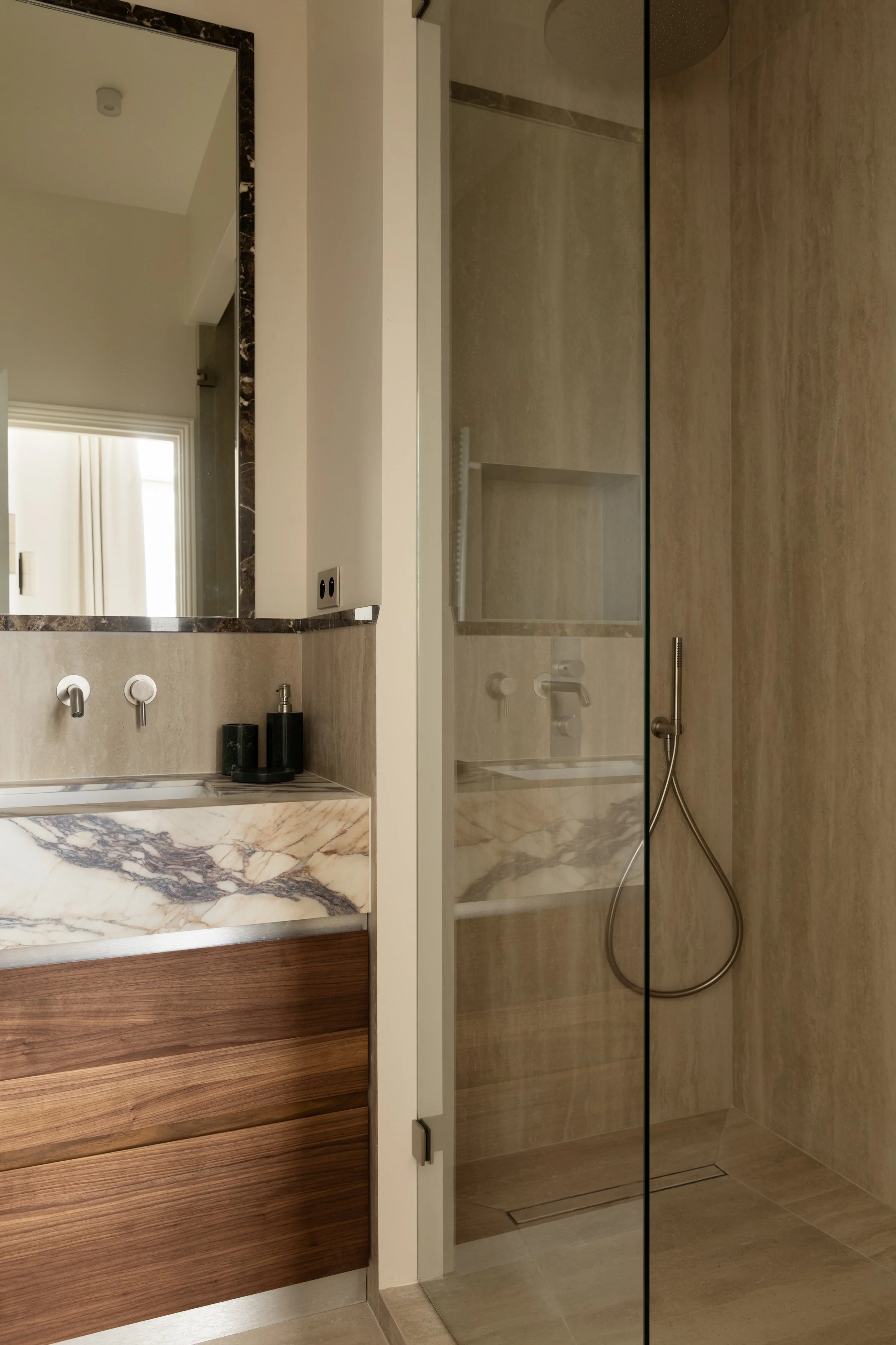 Salle de bains haut de gamme à Paris avec douche à l’italienne vitrée, vasque en marbre veiné, meuble en noyer sur mesure et pierre naturelle – Intérieurs Chomet.