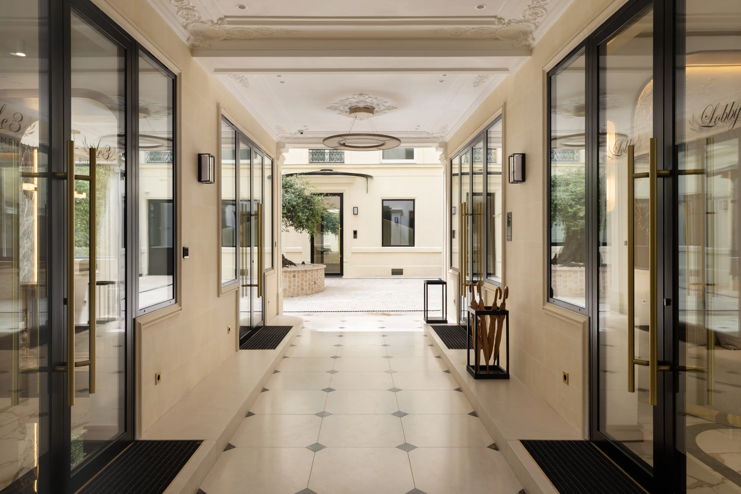 Galerie élégante à Paris avec portes vitrées, moulures classiques et sol en pierre naturelle – Architecture d'intérieur haut de gamme, Intérieurs Chomet.