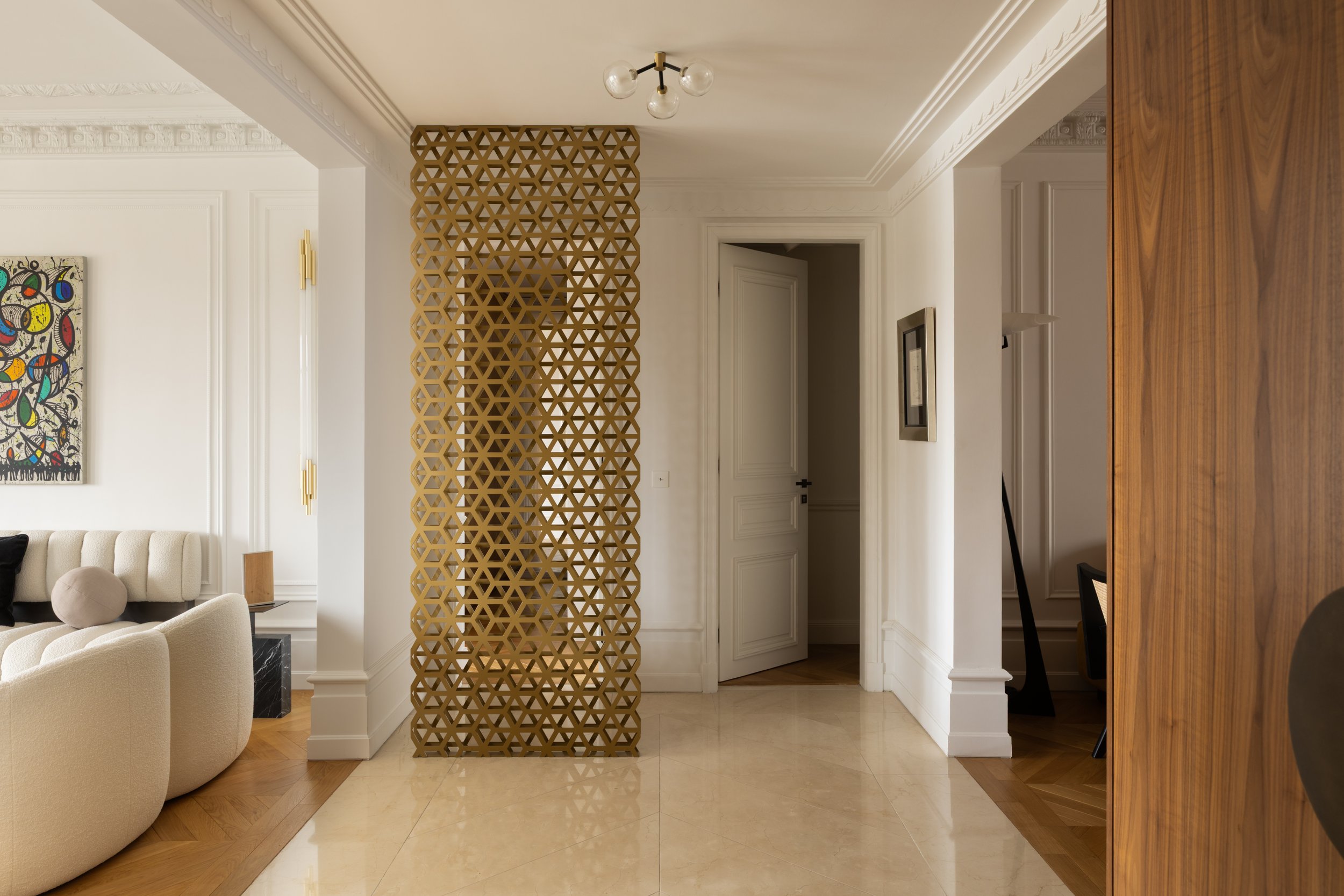 Séparation décorative en métal doré dans un appartement haussmannien avenue de New York à Paris, création élégante et sur mesure.