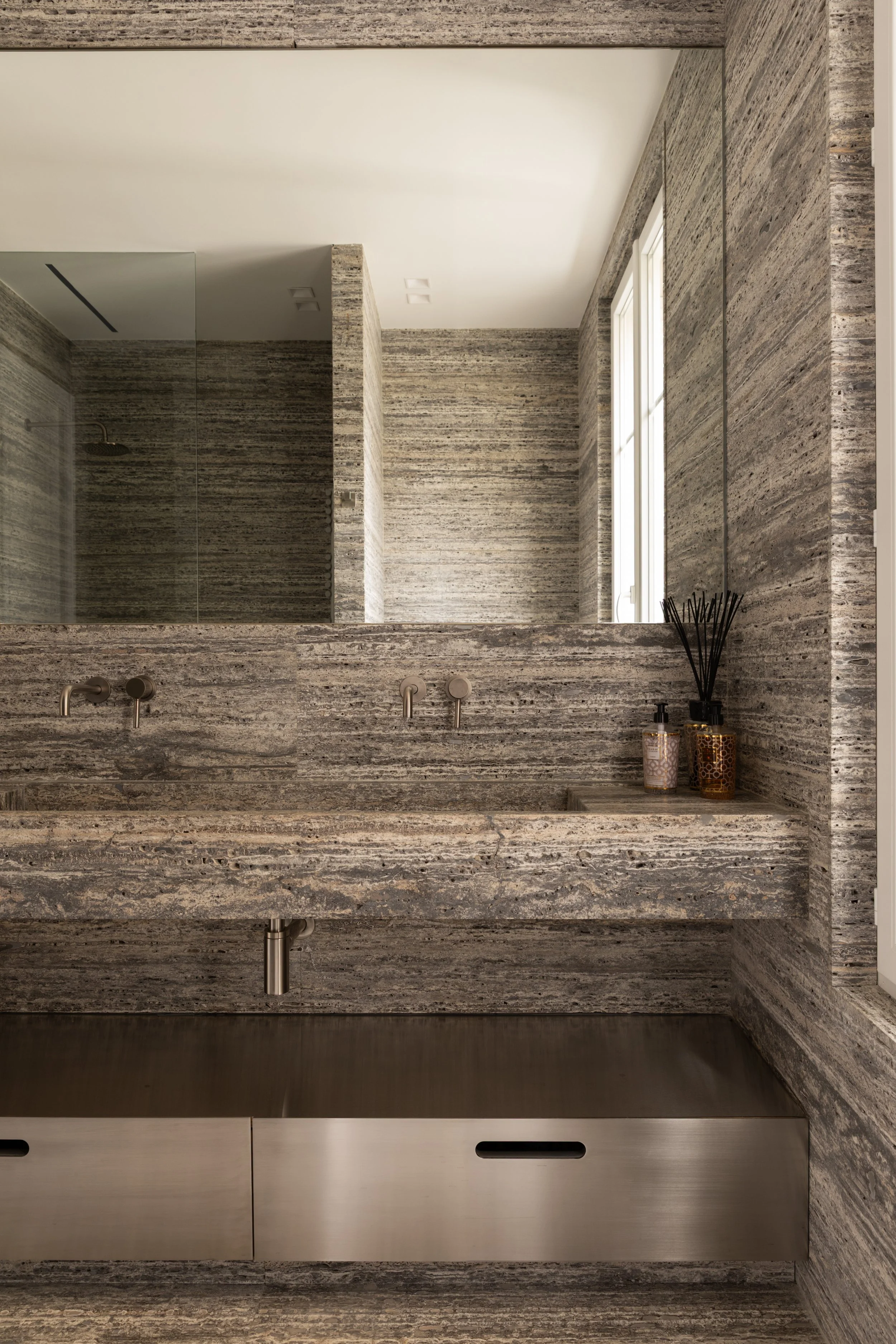 Salle de bain en pierre naturelle aux lignes épurées, ambiance minérale et contemporaine à Paris.