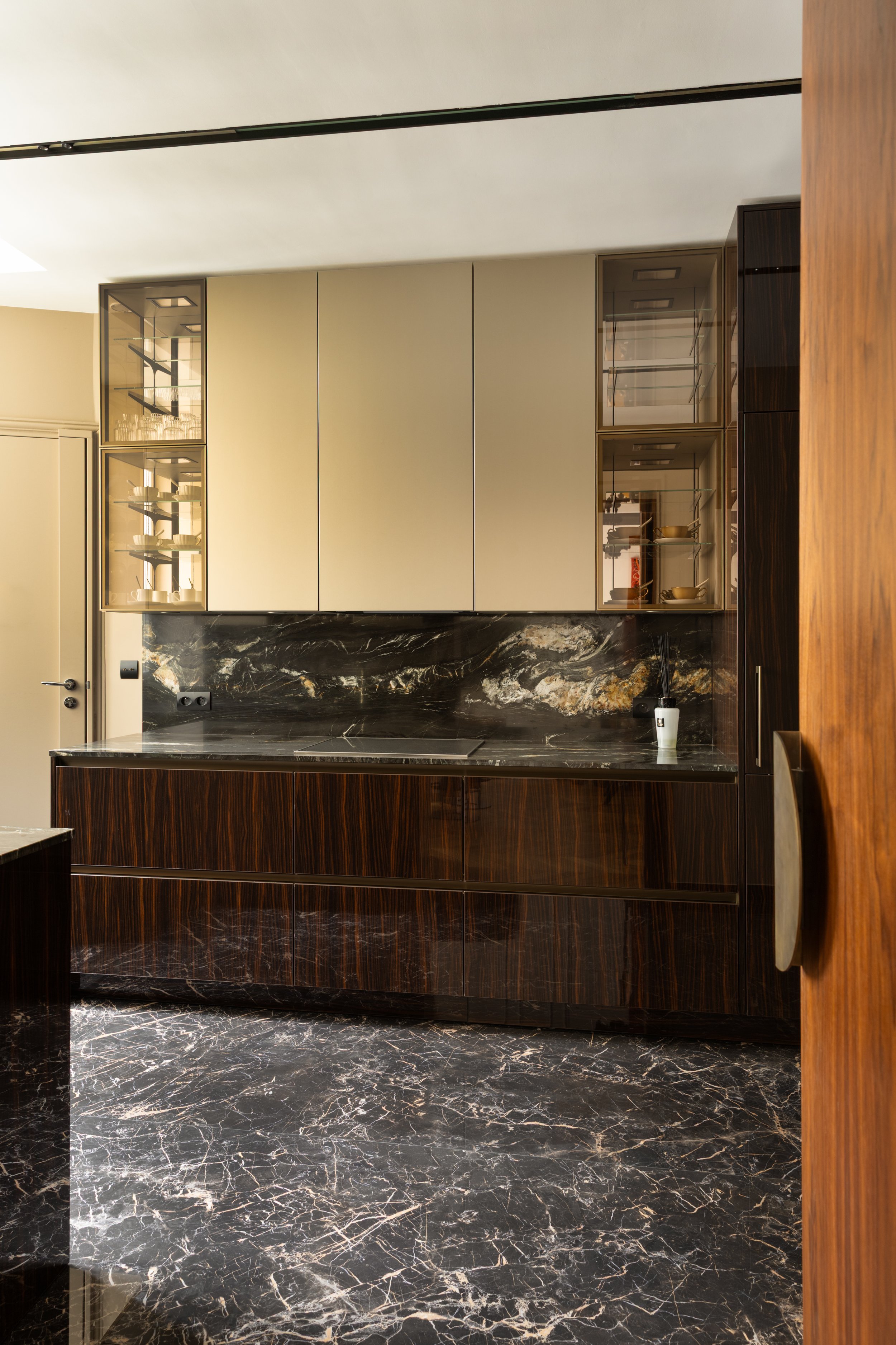 Cuisine décorée avec façades bois et crédence en pierre naturelle, design épuré et raffiné à Paris.