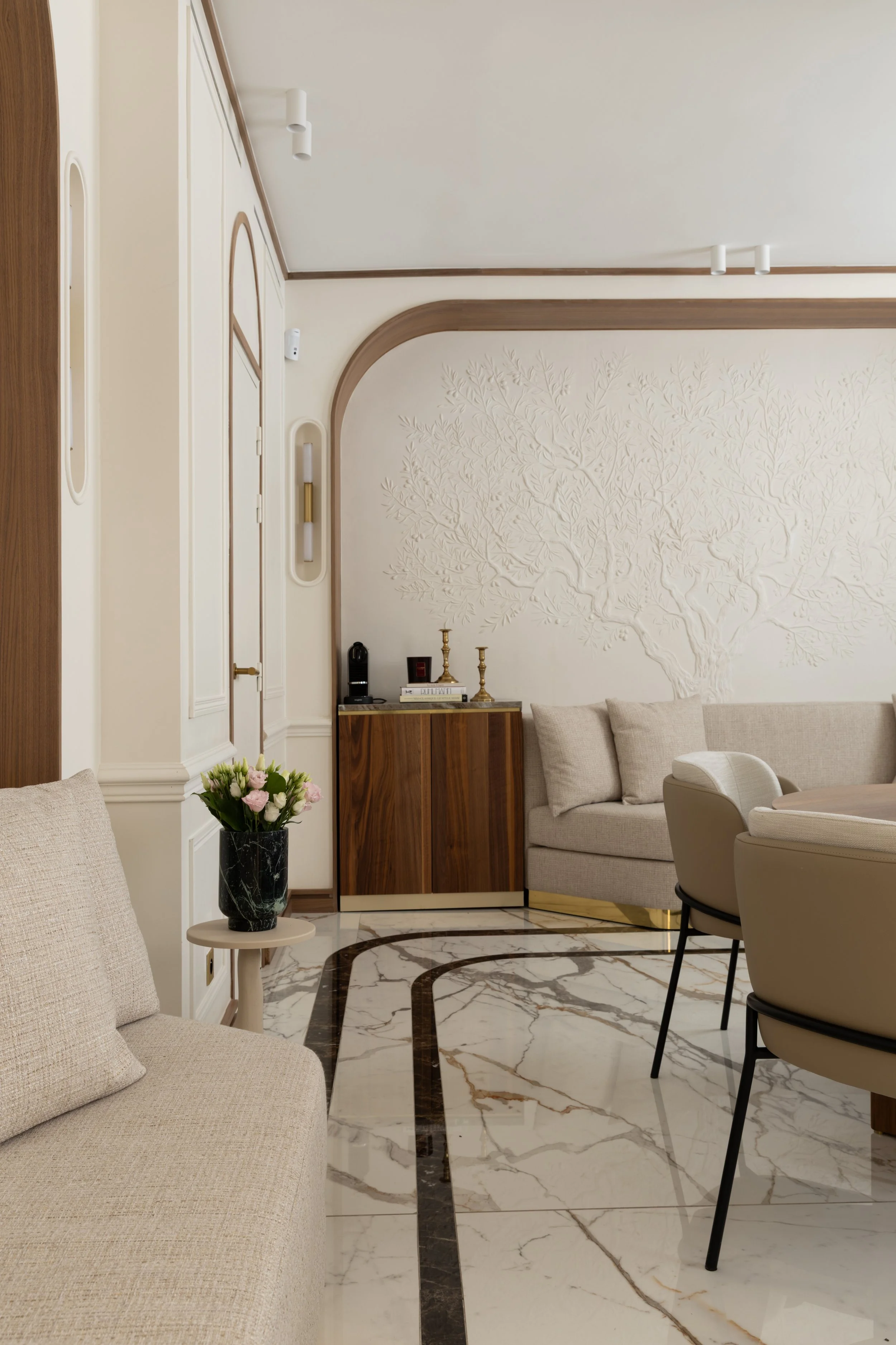 Salon haut de gamme à Paris avec canapé sur mesure, décor mural bas reliefs et finitions raffinées – Architecture d'intérieur Intérieurs Chomet.