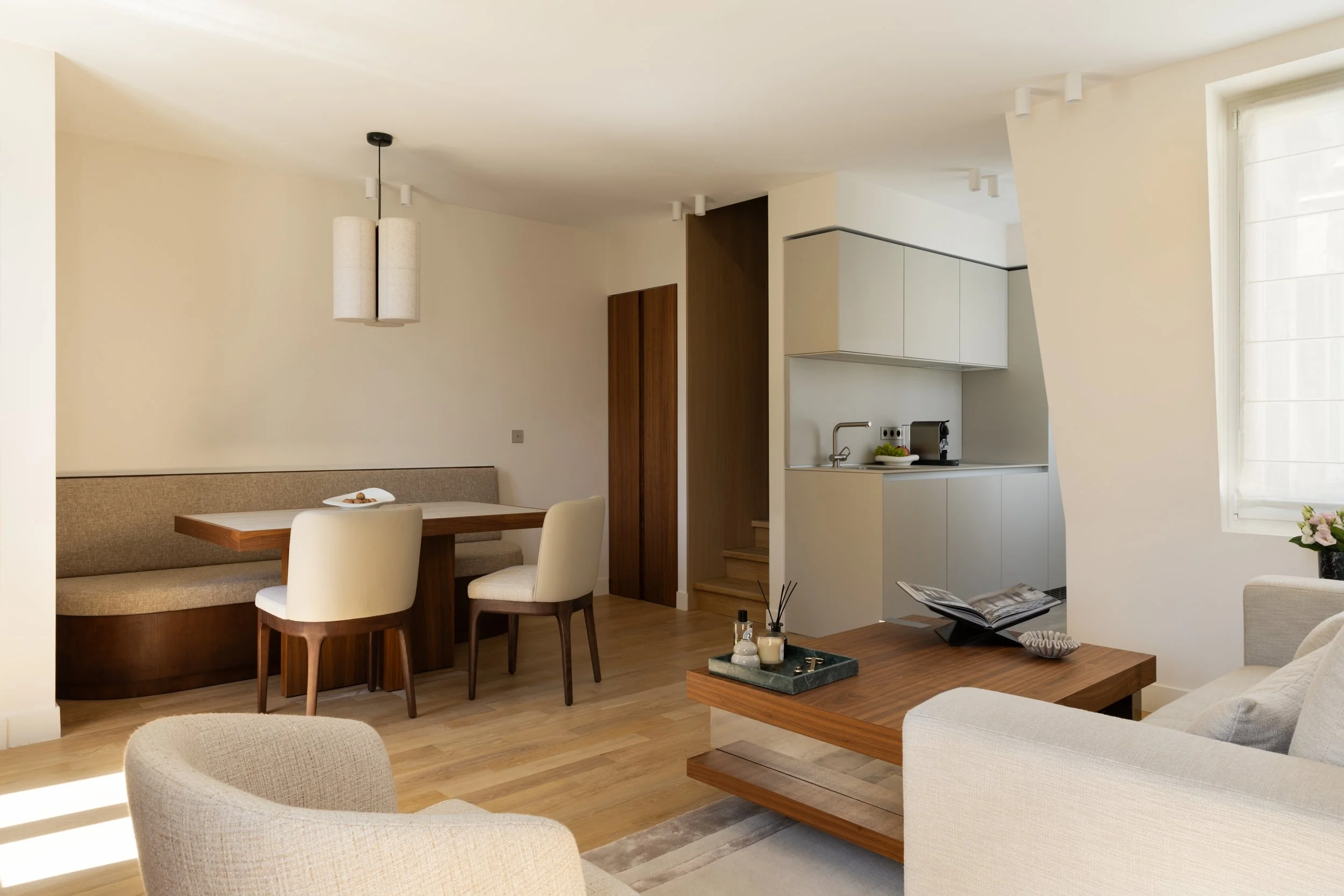 Optimisation d'un appartement parisien avec séjour lumineux, cuisine ouverte, banquette sur mesure et mobilier contemporain – Intérieurs Chomet.