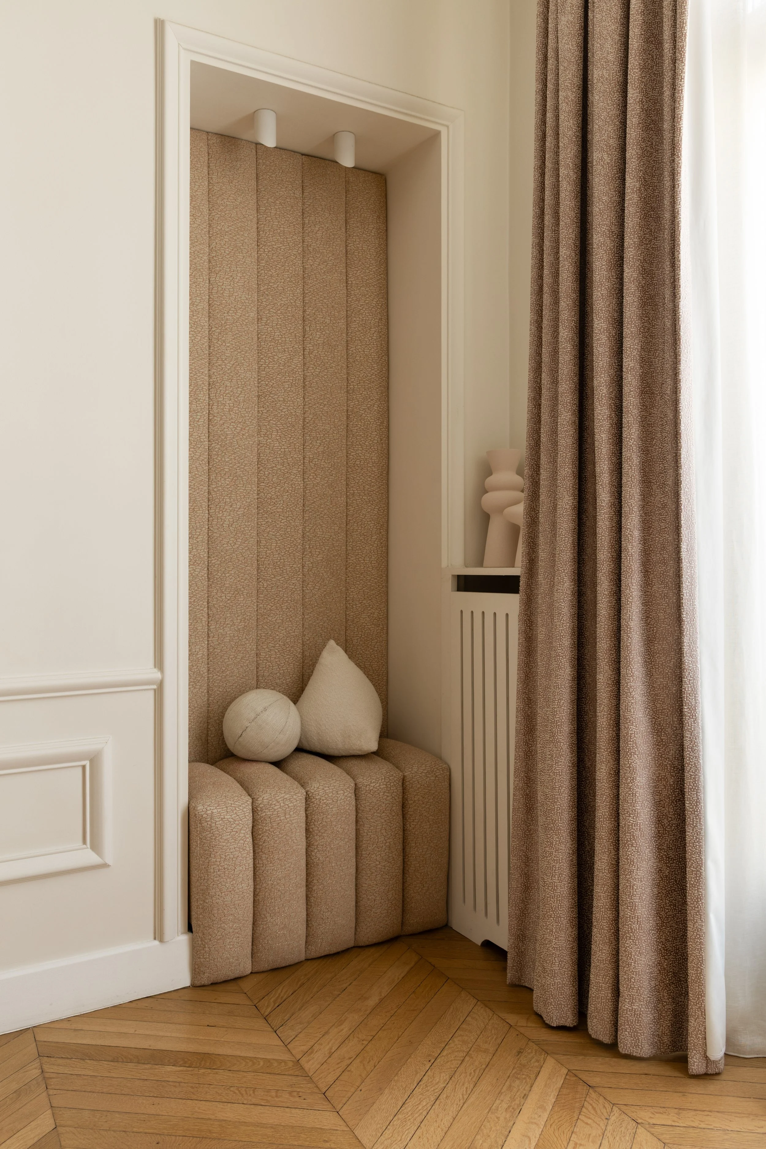 Alcôve avec banquette et panneaux tapissés rosés dans la chambre de la fille, projet Malesherbes à Paris, avec rideaux coordonnés et parquet en point de Hongrie — Intérieurs Chomet.
