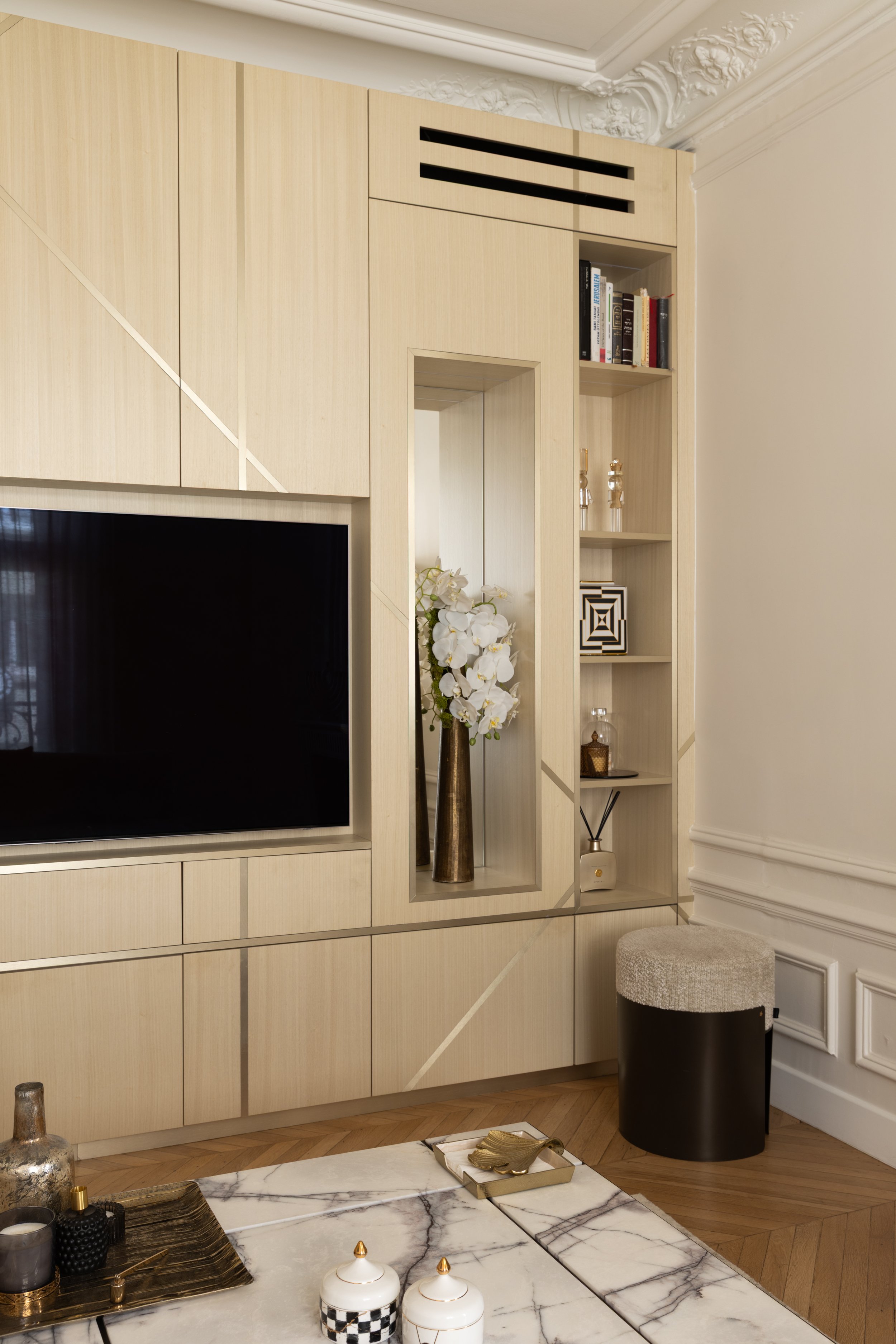 Détail du meuble TV sur mesure du projet Malesherbes à Paris, en bois clair avec incrustations dorées, niche en miroir et étagères intégrées — Intérieurs Chomet.