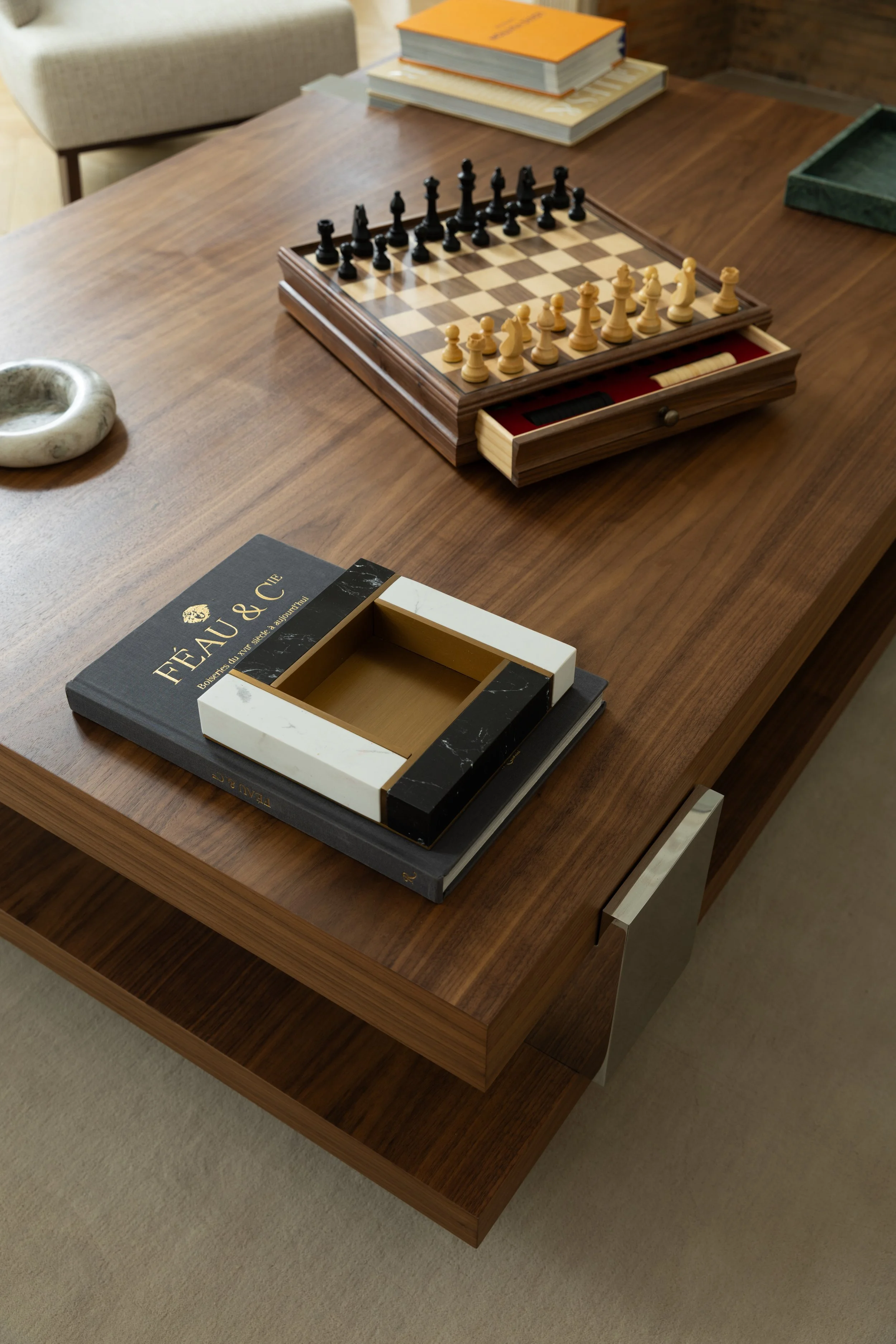 Table basse en bois sur mesure avec jeu d'échecs et objets décoratifs dans un salon haut de gamme à Paris – Intérieurs Chomet.