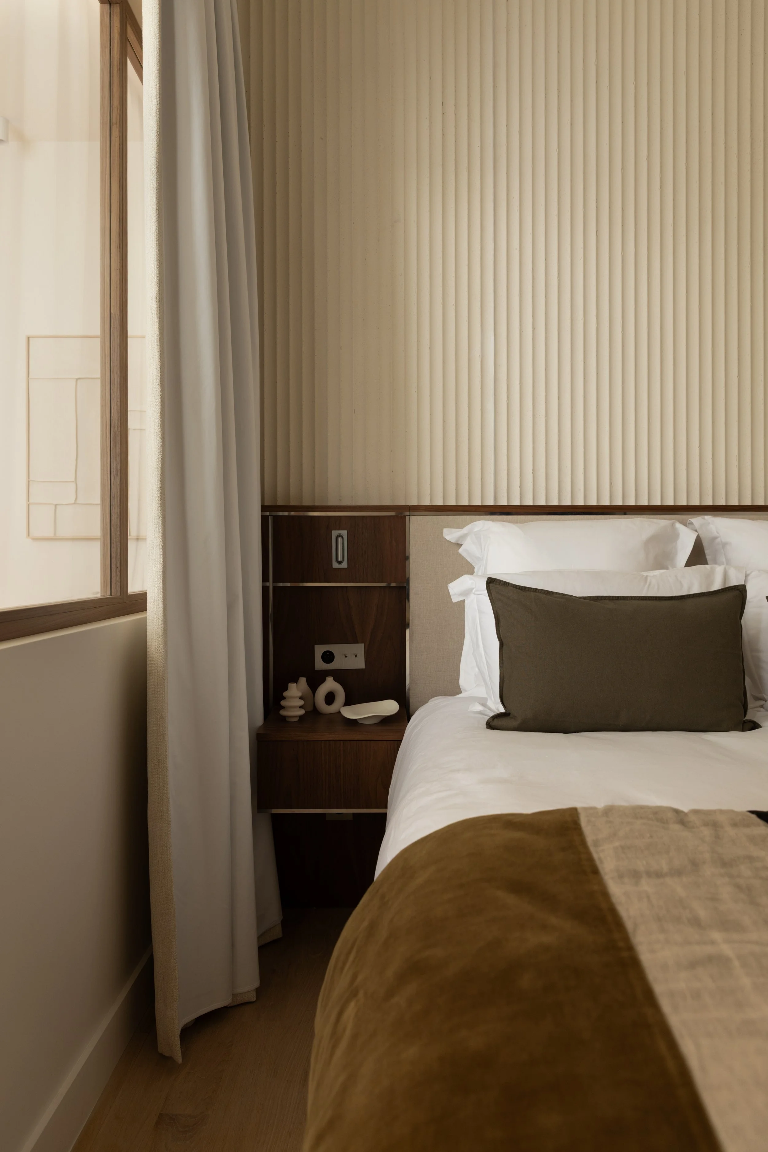 Chambre contemporaine à Paris avec tête de lit sur mesure en bois et tissu, panneau mural cannelé et linge de lit raffiné – Intérieurs Chomet.