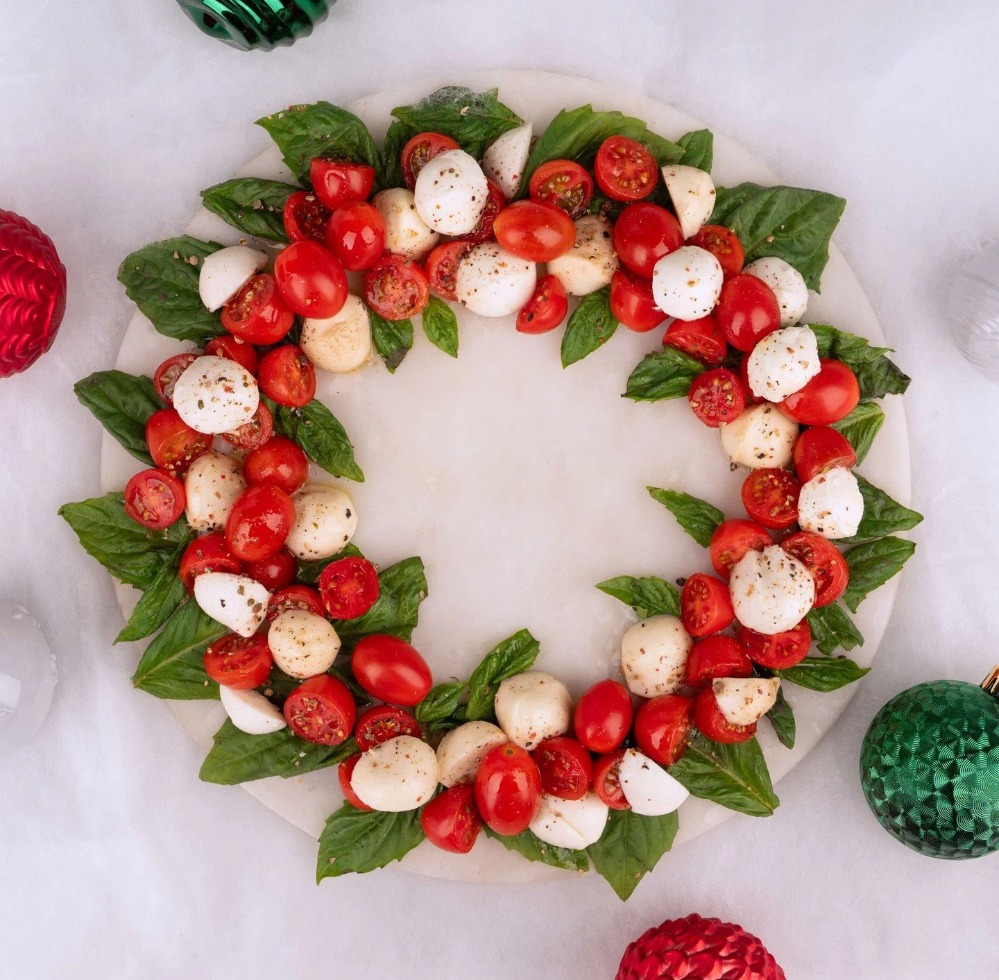 A holiday wreath you can actually eat. 🎄

Fresh basil, cherry tomatoes, and our Marinated Mozzarella + Ciliegini make this caprese wreath the easiest win on any table. Get the recipe in our bio!