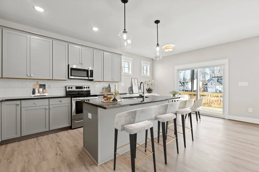 pacious kitchen featuring a large central island, white cabinets, and stylish barstools