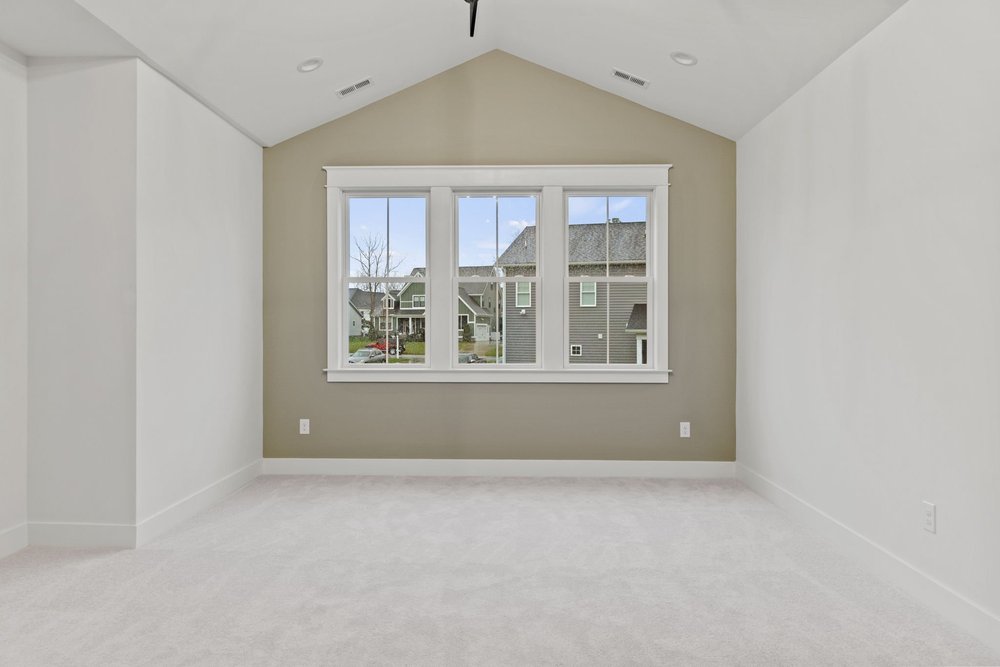 Room with vaulted ceilings and a large window providing natural light.