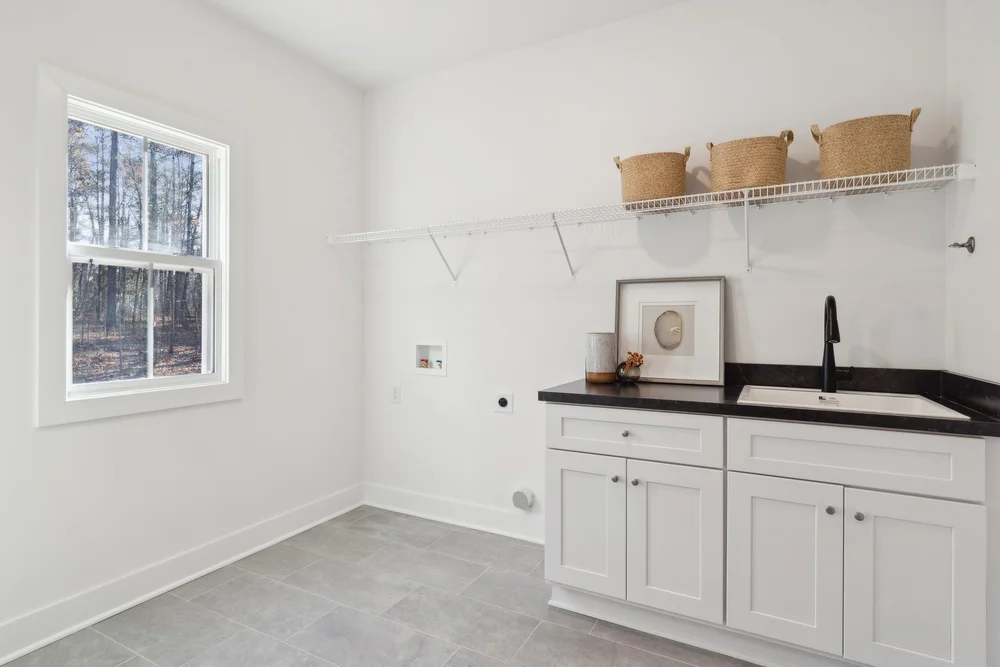 Laundry Room in the Bonaire Plan. White Cabinets with Black Countertops