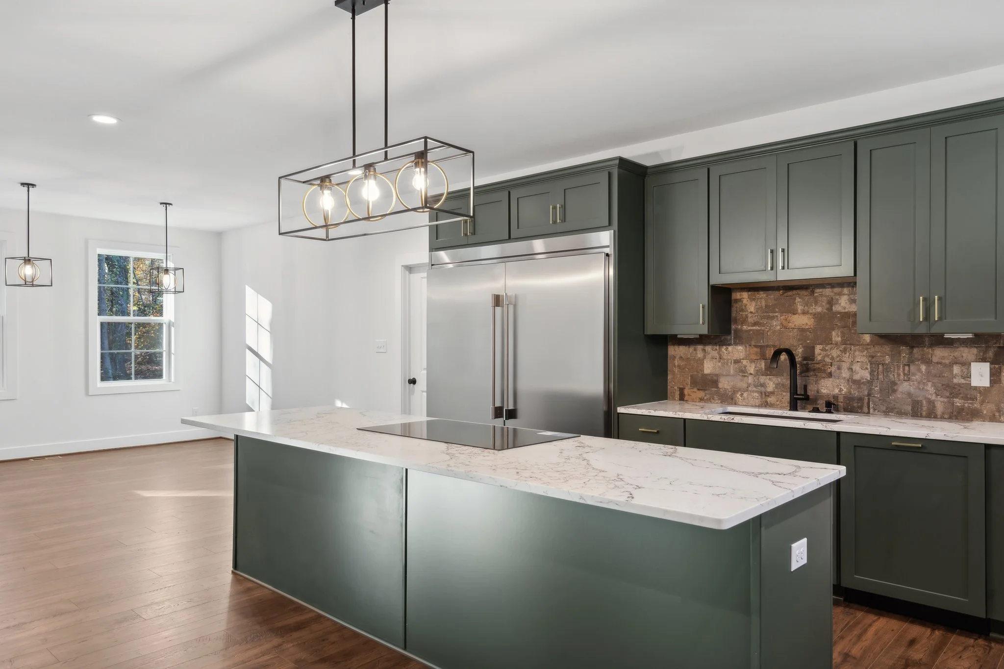 Kitchen view featuring dual pendant lights and stainless steel appliances.